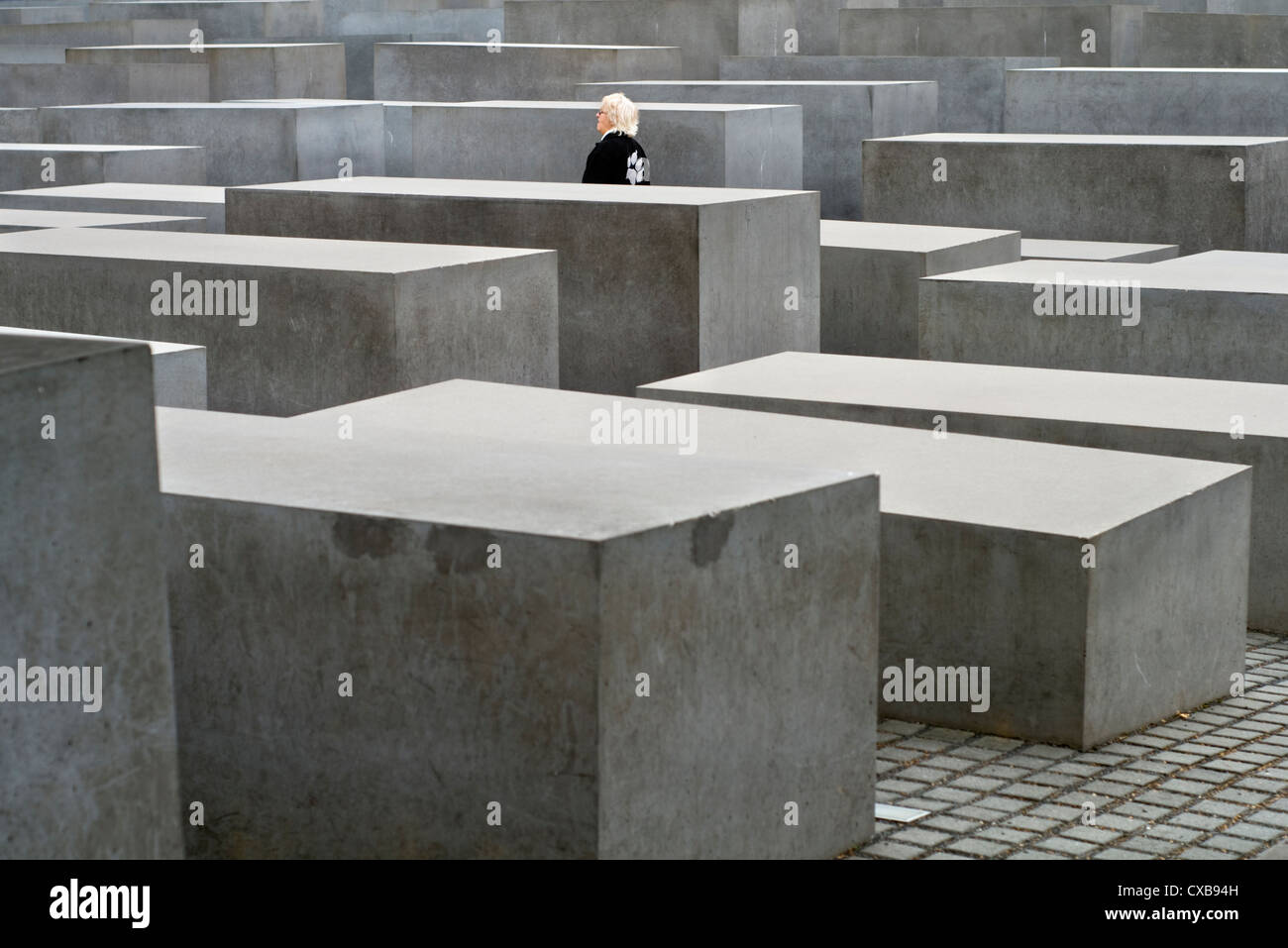 Eine weibliche Touristen zu Fuß durch das Holocaust-Mahnmal in Berlin, Deutschland Stockfoto