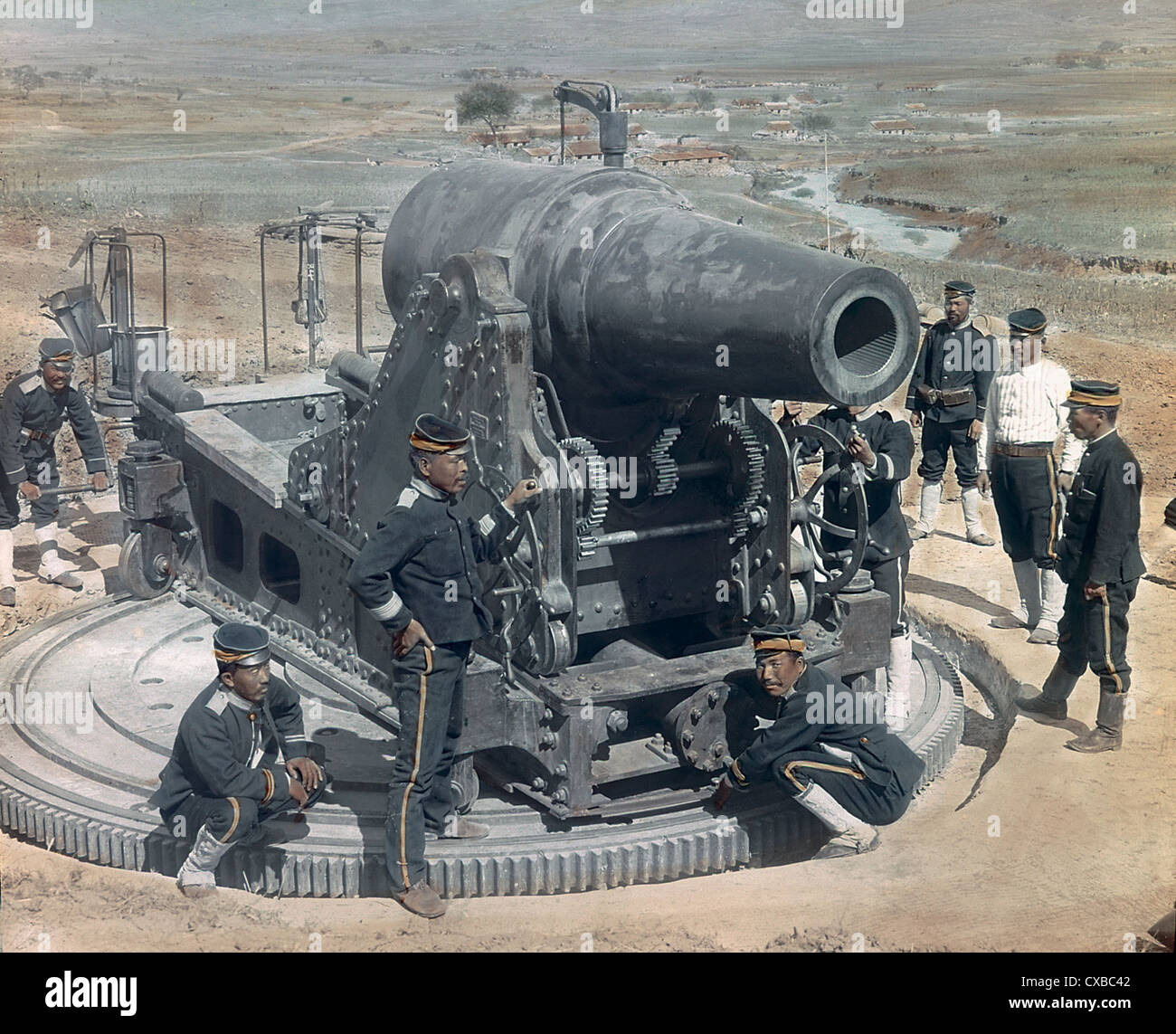 Koloriertes Foto von japanischen Soldaten um eine 28 cm Haubitzerkanone versammelt, bekannt als "Osaka Baby", Port Arthur, China, 1905. (Foto von Burton Holmes) Stockfoto