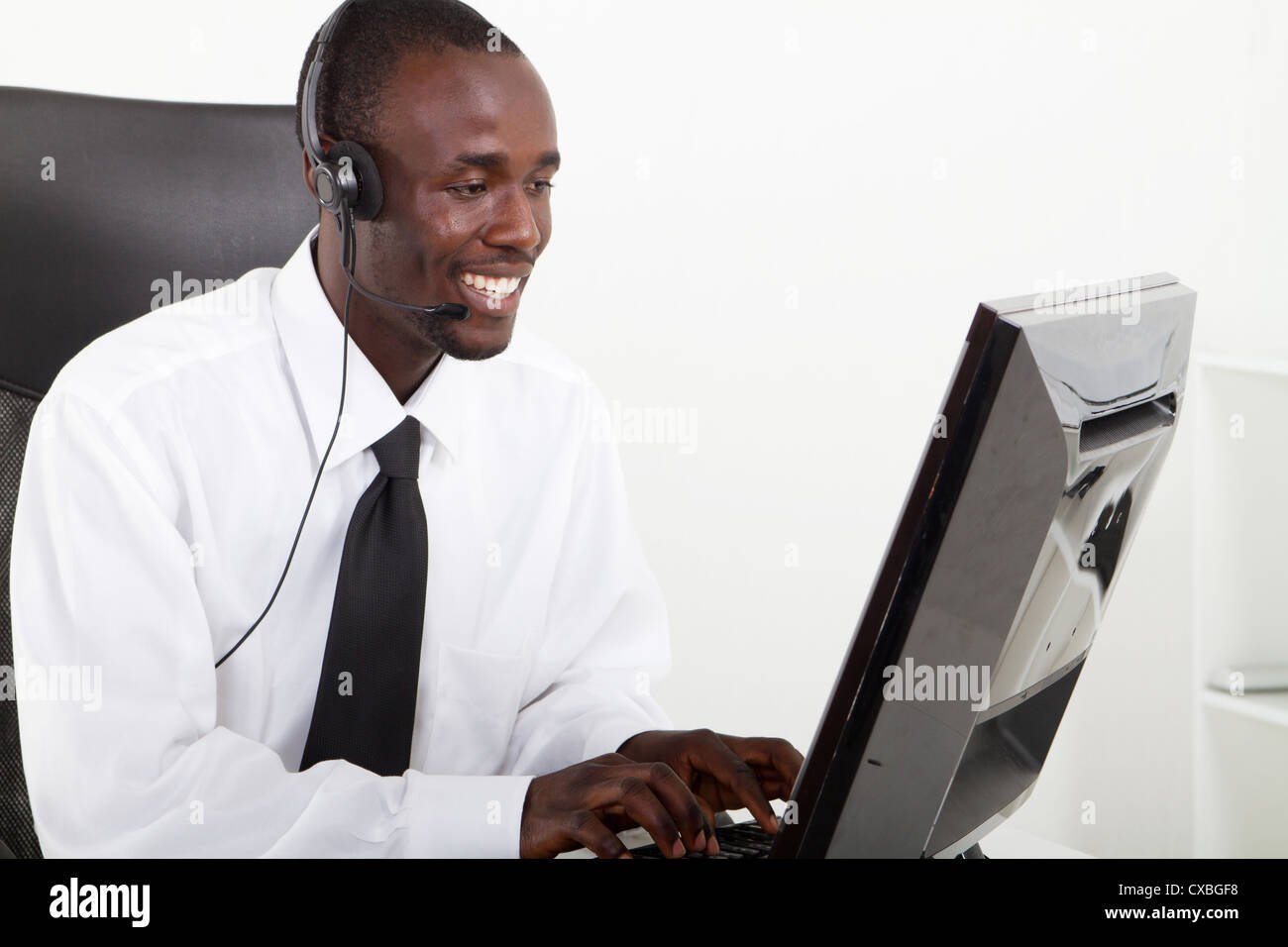 Afrikanische amerikanische Geschäftsmann mit Kopfhörer sitzen am Schreibtisch Stockfoto