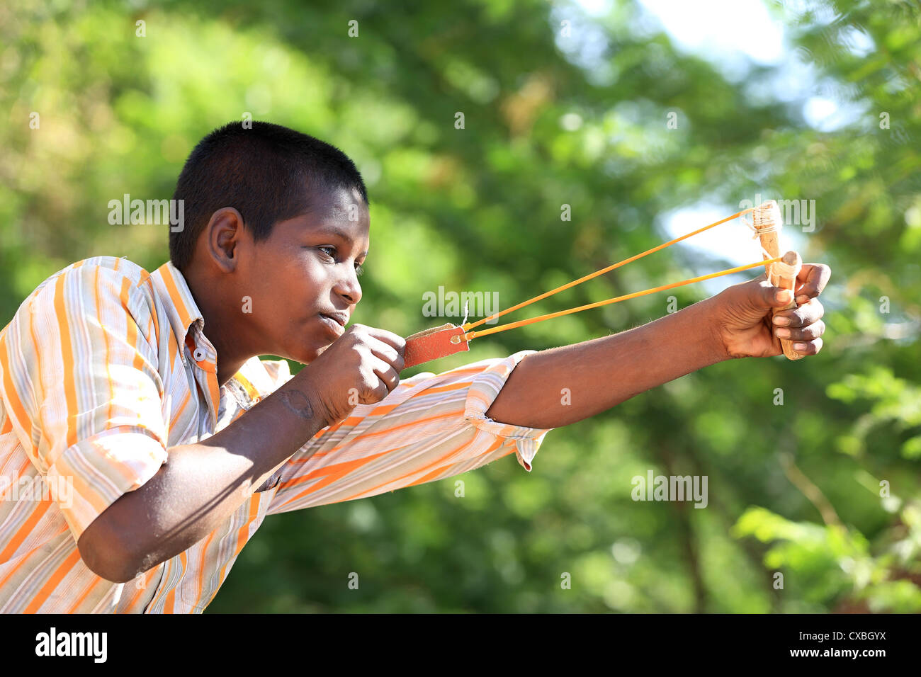 Indischer Junge mit einer Steinschleuder Vögel Andhra Pradesh in Indien zu töten versuchen Stockfoto