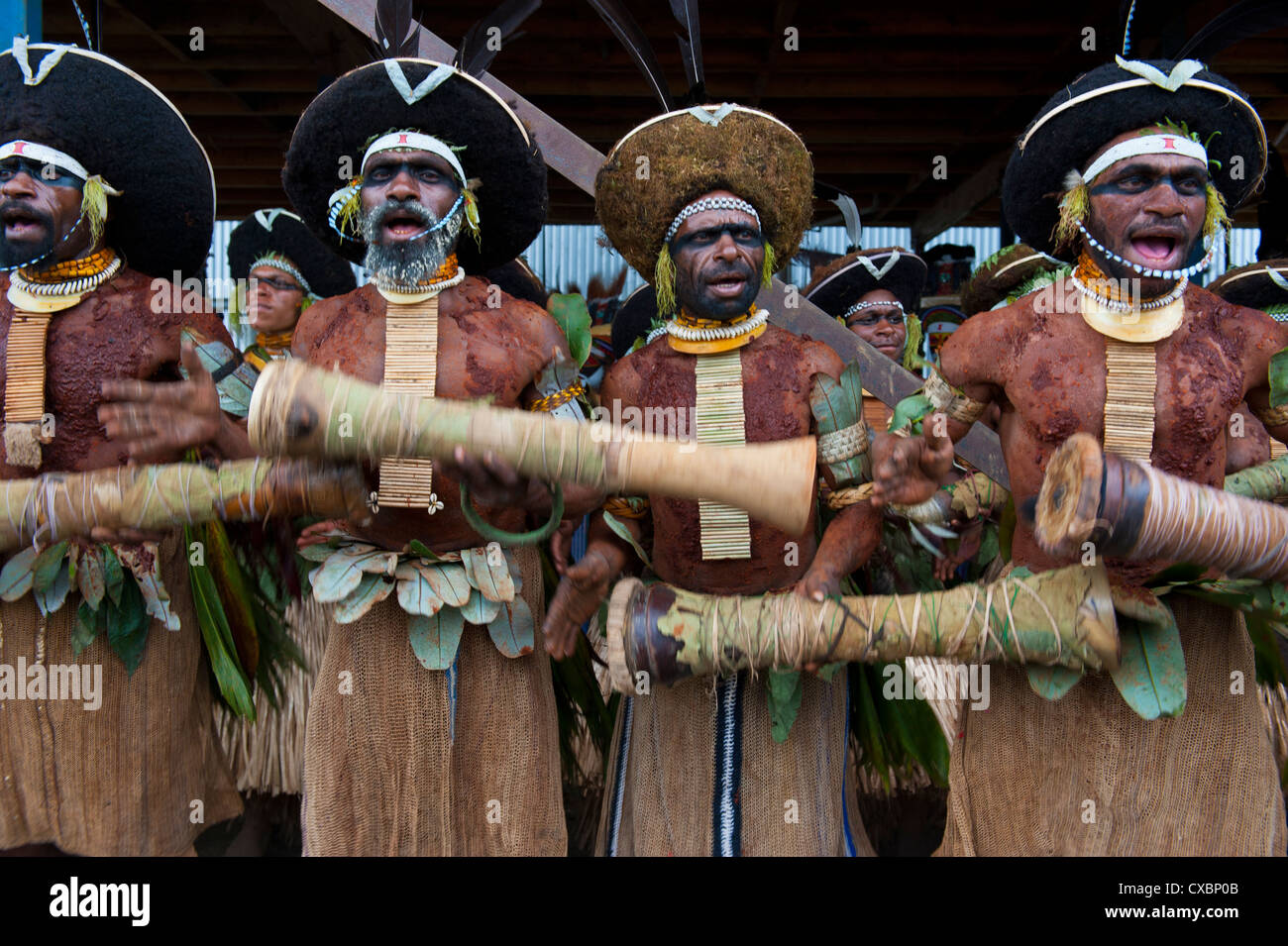 Bunt gekleidet und Gesicht gemalt lokalen Stämme feiert die traditionelle Sing Sing im Hochland von Papua-Neuguinea Stockfoto