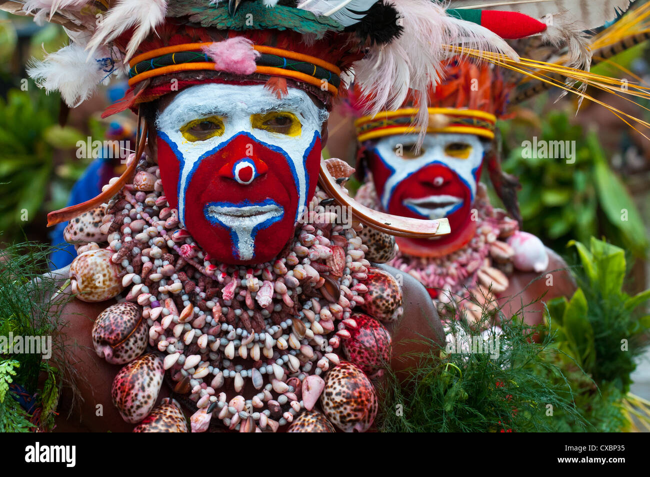 Bunt gekleidet und Gesicht gemalt lokalen Stämme feiert die traditionelle Sing Sing, Enga, Hochland von Papua-Neuguinea Stockfoto