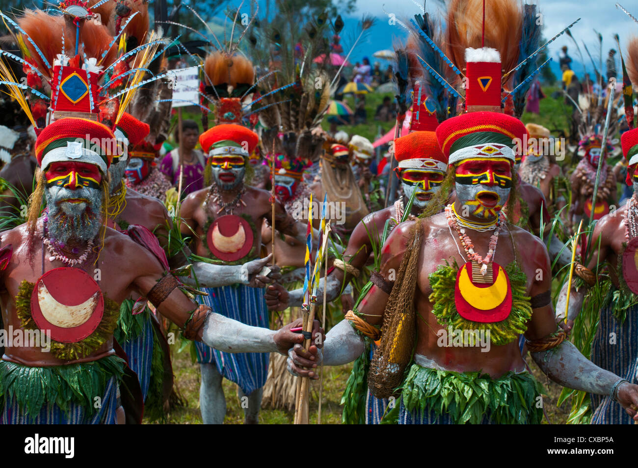Bunt gekleidet und Gesicht gemalt lokalen Stämme feiert die traditionelle Sing Sing im Hochland von Papua-Neuguinea Stockfoto