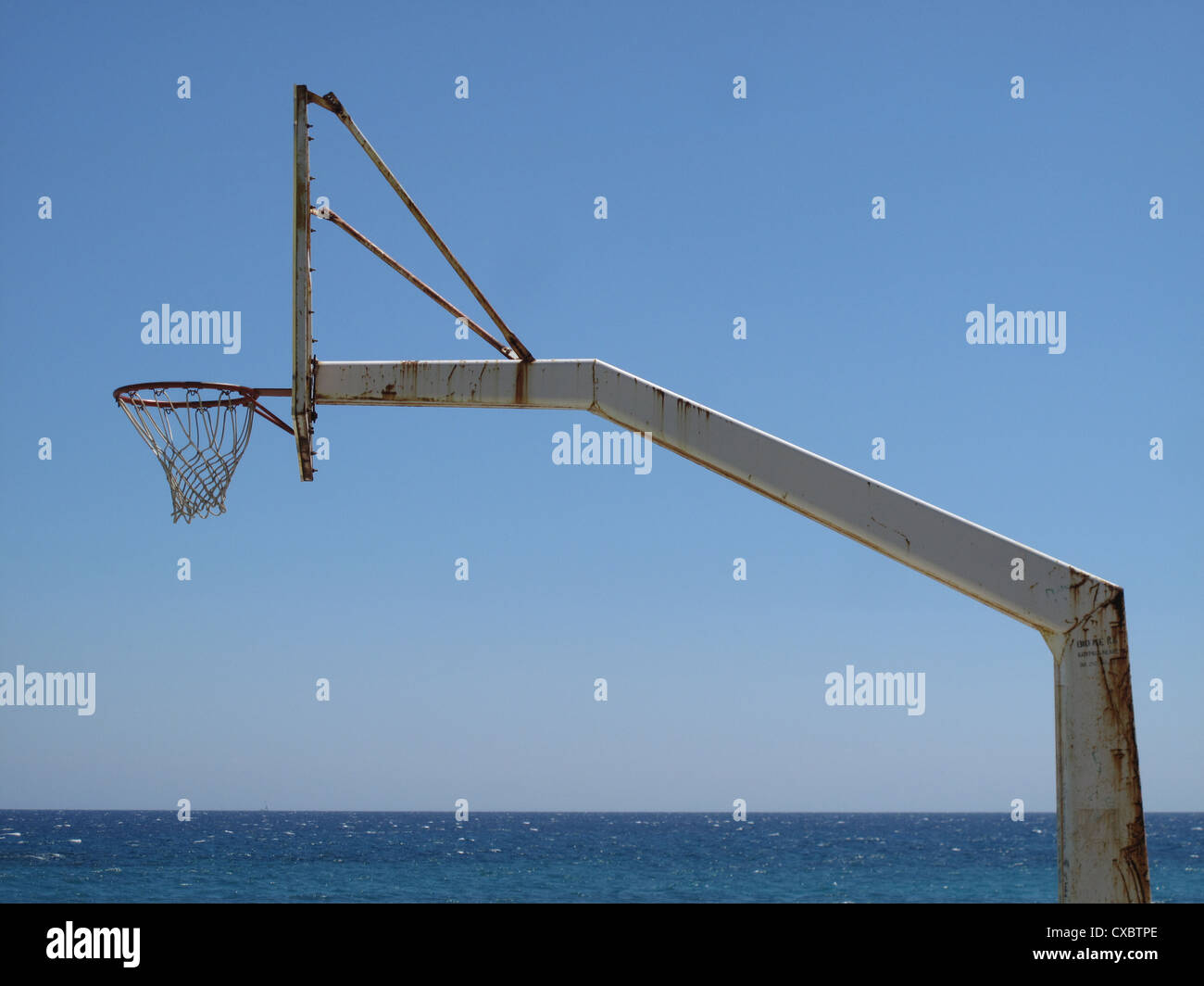 Seitenansicht des einen Korb Ball Hoop auf einem rostigen Metallgestell mit Blick aufs Meer Stockfoto