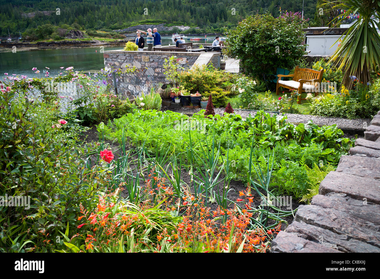 Am Meer kleinen Gemüsegarten Garten wachsen Blumen und Gemüse und eine kleine Liegewiese mit Sitz Stockfoto