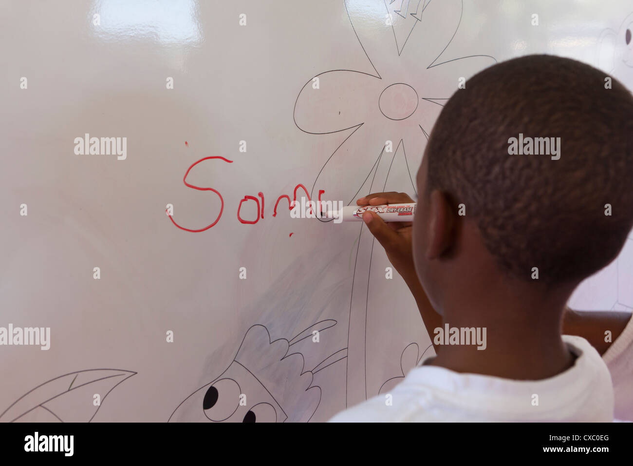 African American Boy auf Whiteboard schreiben Stockfoto