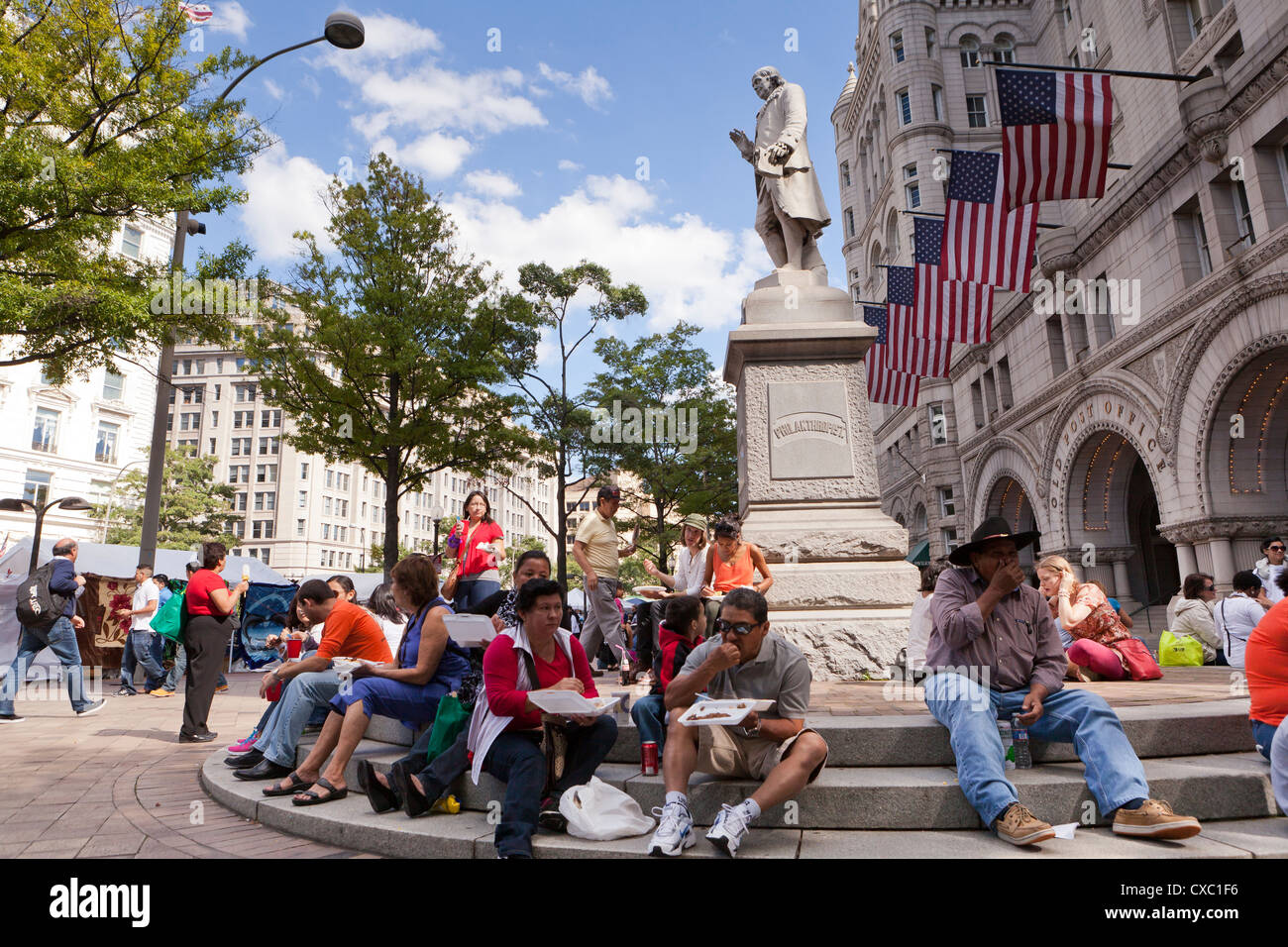 Menschen Essen rund um die Benjamin Franklin Statue in Washington, DC Stockfoto