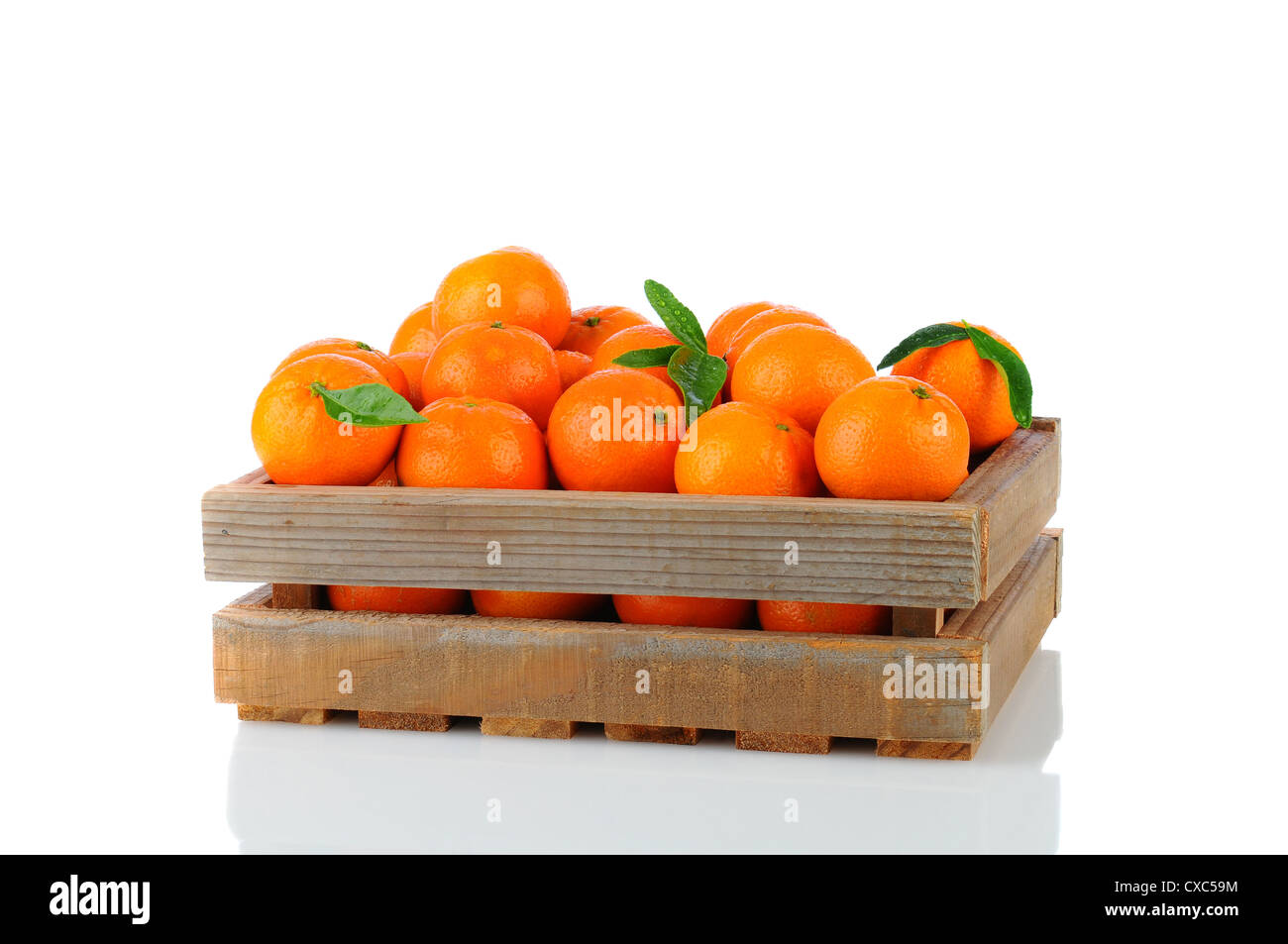 Ein Holz rustikal Kiste voll von Clementine Mandarinen. Querformat auf einem weißen Hintergrund mit Reflexion. Stockfoto
