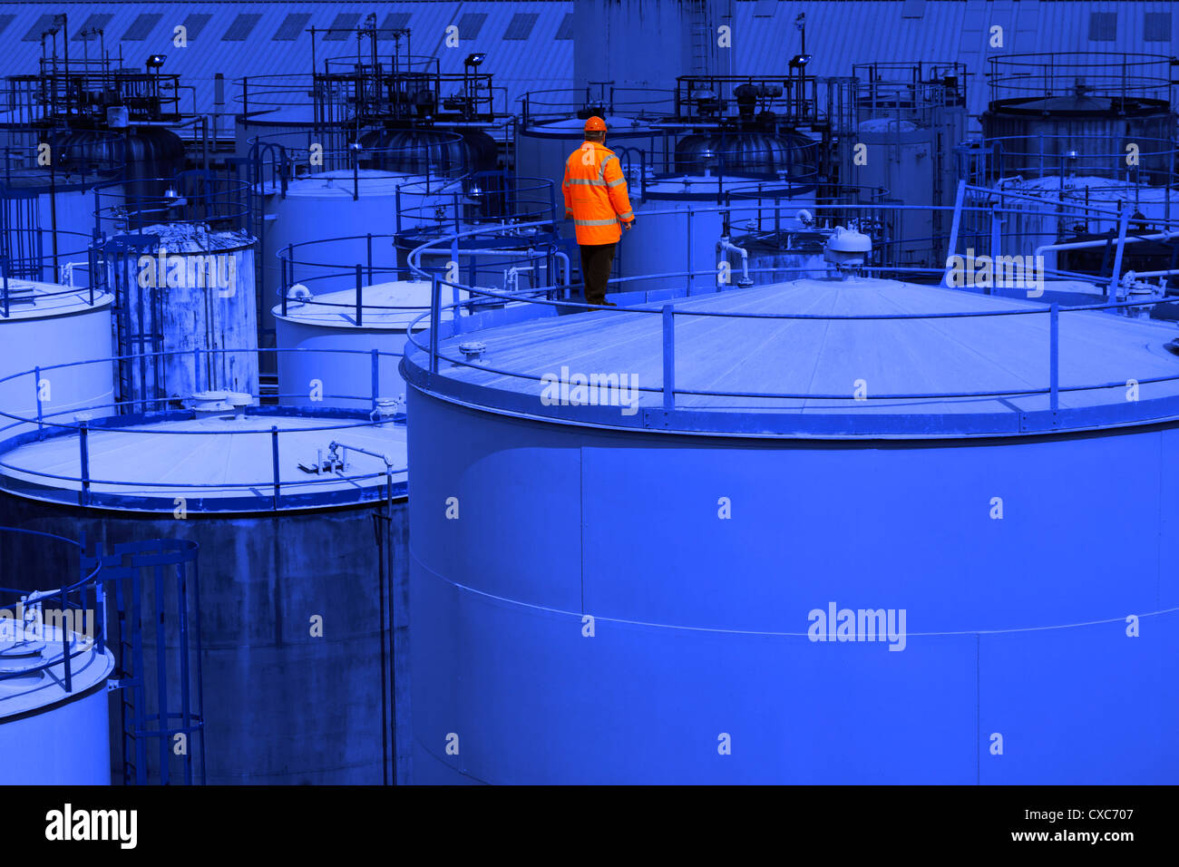 Chemiefabrik Prozess Betreiber Orangen auf blau Petro-chemische Industrie-Lagerung-Tank stehend Stockfoto