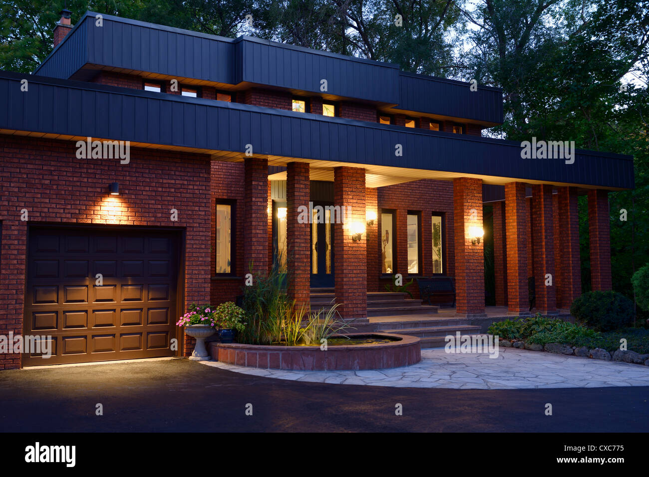 Vor einem Haus aus rotem Backstein mit Licht in der Dämmerung mit Teich und Stein Veranda Toronto Ontario Kanada Stockfoto