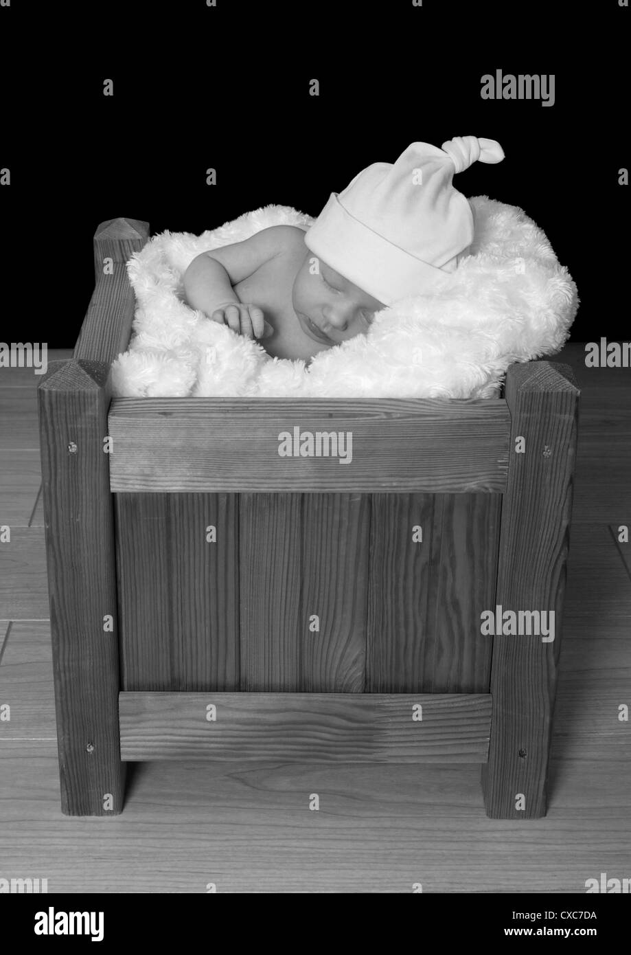 Junge baby Mädchen trägt einen Hut, schläft in einem hölzernen Kasten Stockfoto