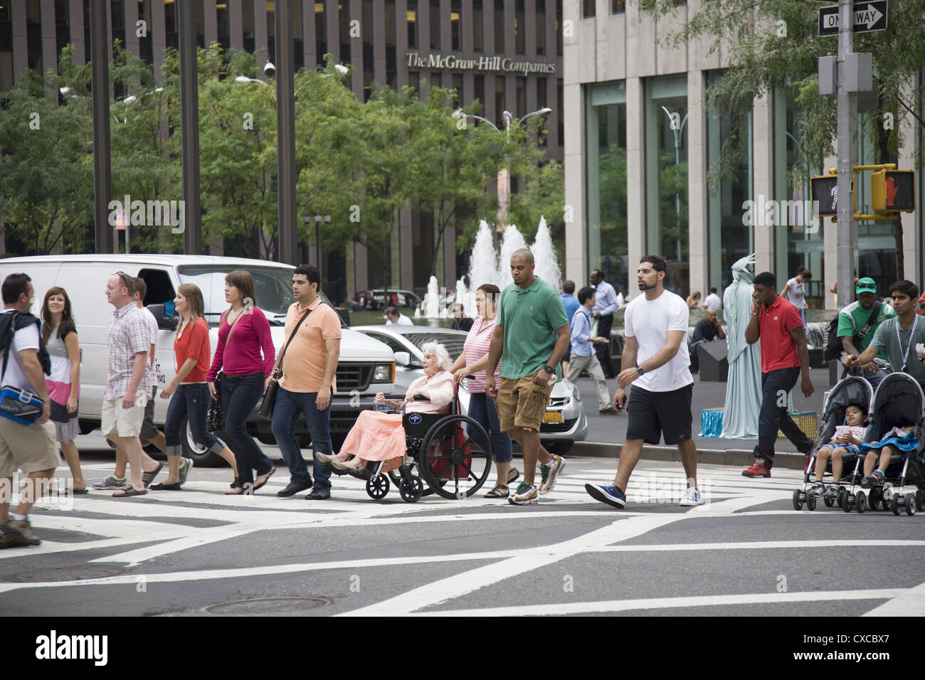 Fußgänger überqueren Sie die Straße an der 50th Street und Avenue of the Americas Richtung Rockefeller Center. Stockfoto