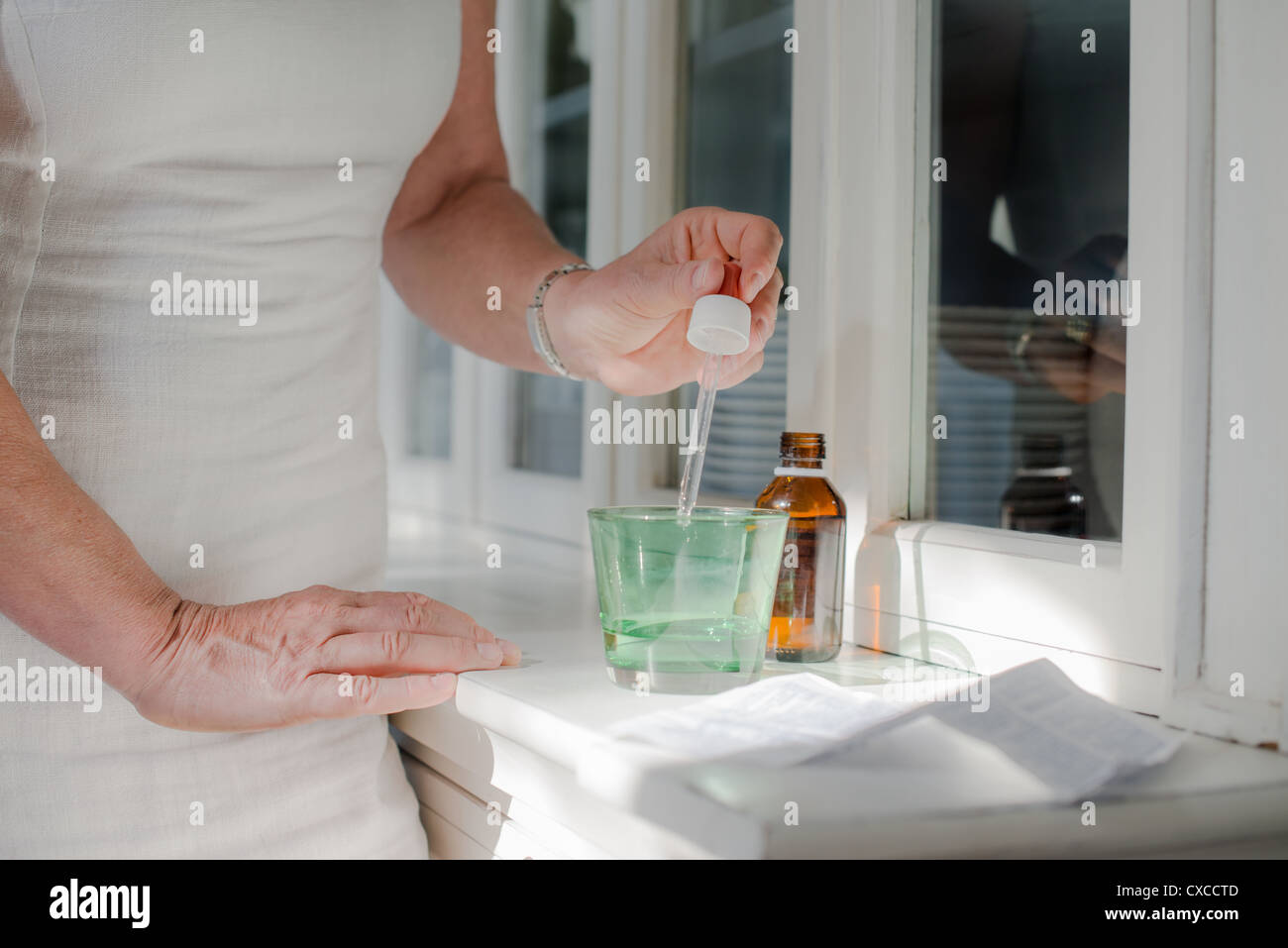 Gesundheitsfragen und Menschen, Reife Frau mit rezeptpflichtigen Medikamenten und Wasser. Verkürzte Ansicht Stockfoto