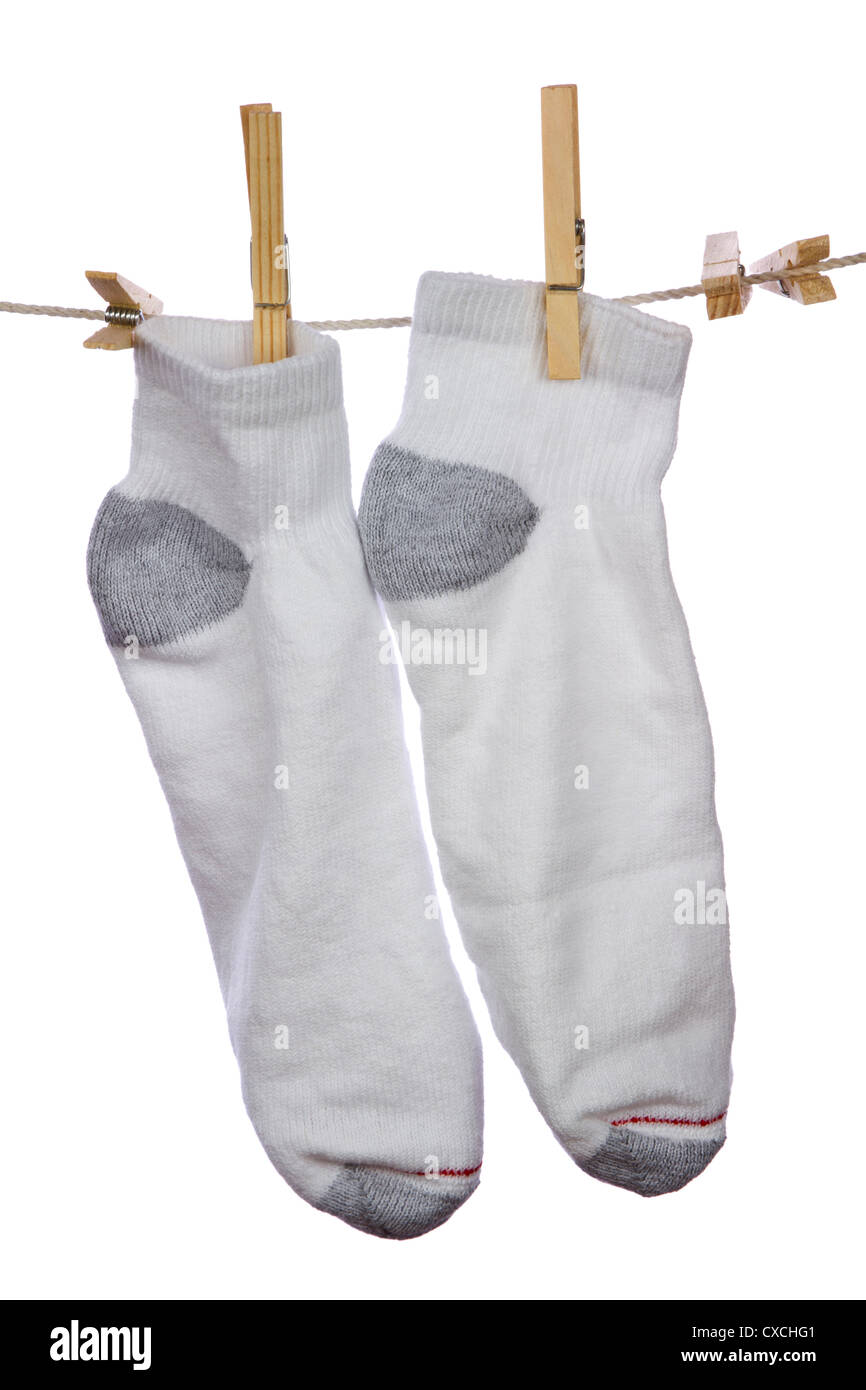 Frische saubere weiße Baumwollsocken aufhängen und trocknen auf der Wäscheleine auf weißem Hintergrund. Stockfoto