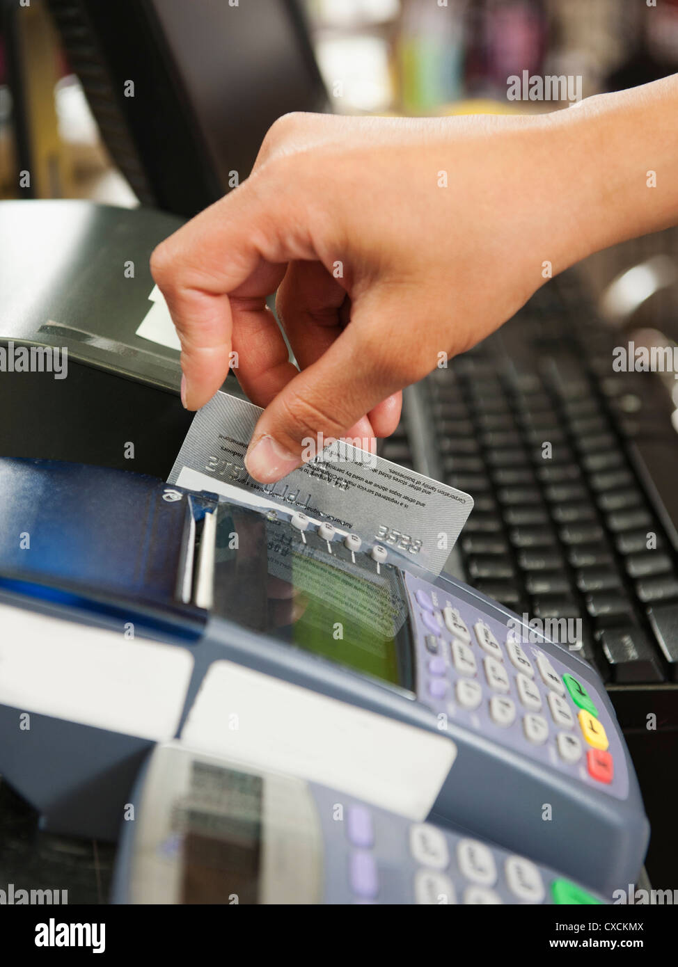 Gemischte Rassen Frau streichen Kreditkarte im store Stockfoto