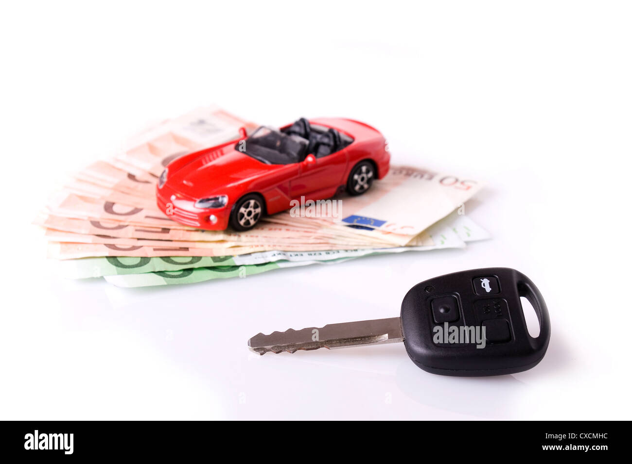 Neuwagen Konzept - Schlüssel und ein rotes Auto mit Euro-Banknoten (selektiven Fokus auf den Schlüssel) Stockfoto