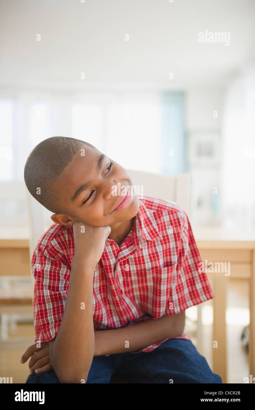 Afrikanische amerikanische Junge sitzt mit Kopf in Händen denken Stockfoto