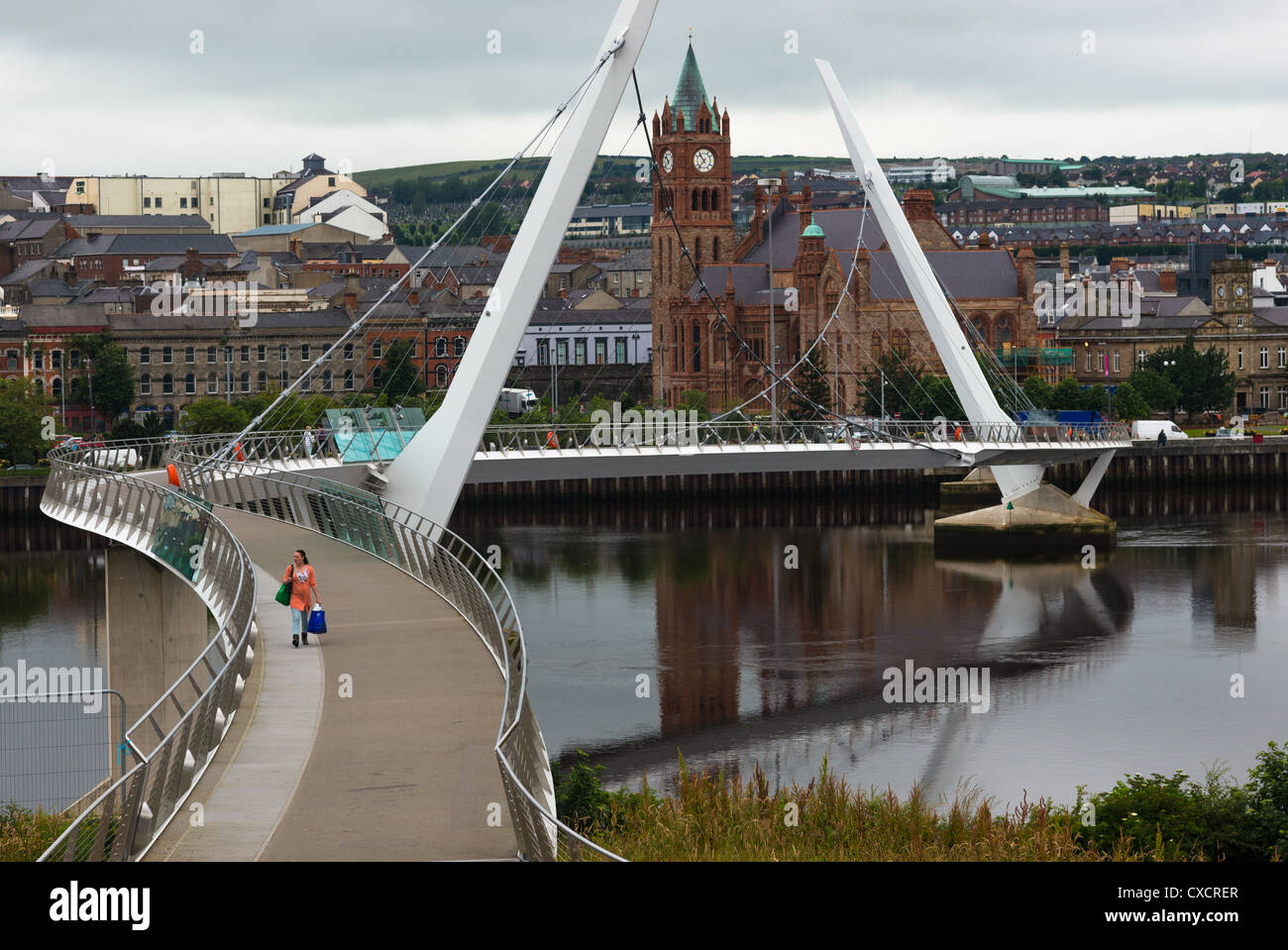 Die Peace Bridge über den Fluss Foyle mit Gildehaus, Derry, Nordirland. Stockfoto