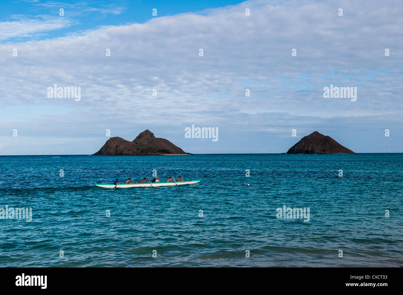 Ausleger-Kanu-Team aus Lanikai Beach, Kailua Bay, Oahu, Hawaii. Mokulua Inseln im Hintergrund Stockfoto