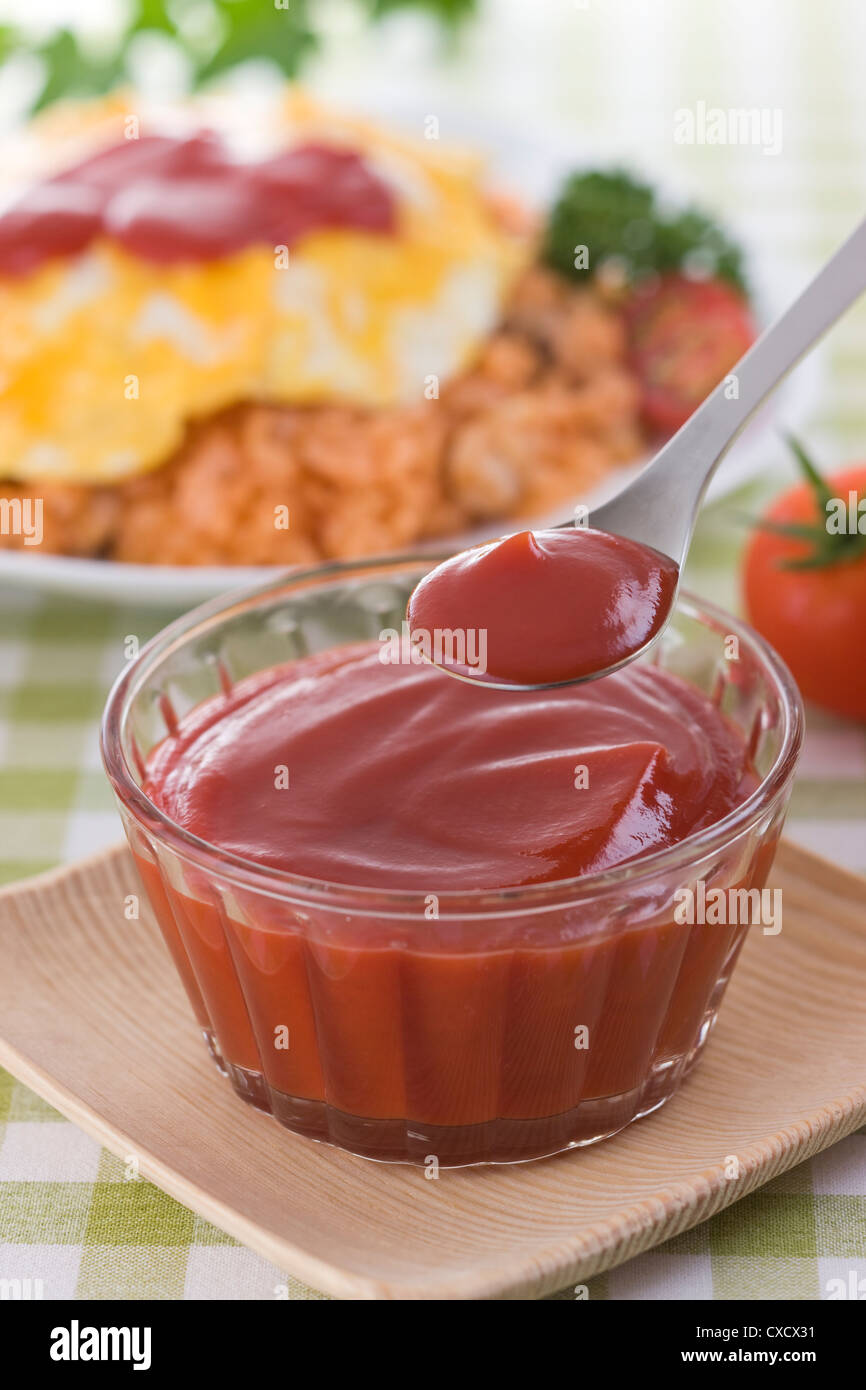 Scooping Tomatenketchup mit Löffel Stockfoto