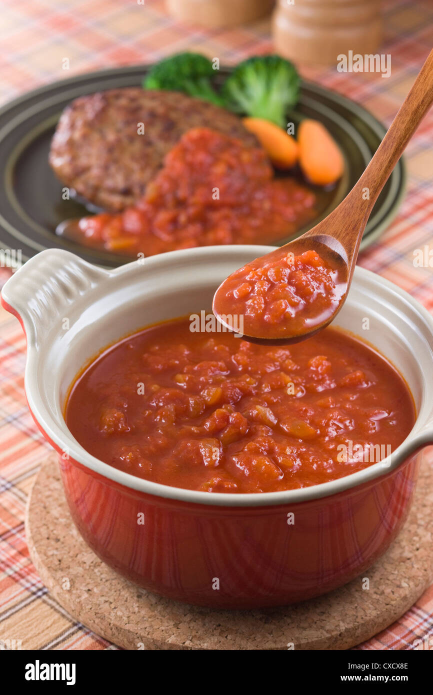 Scooping Tomatensauce mit Löffel Stockfoto