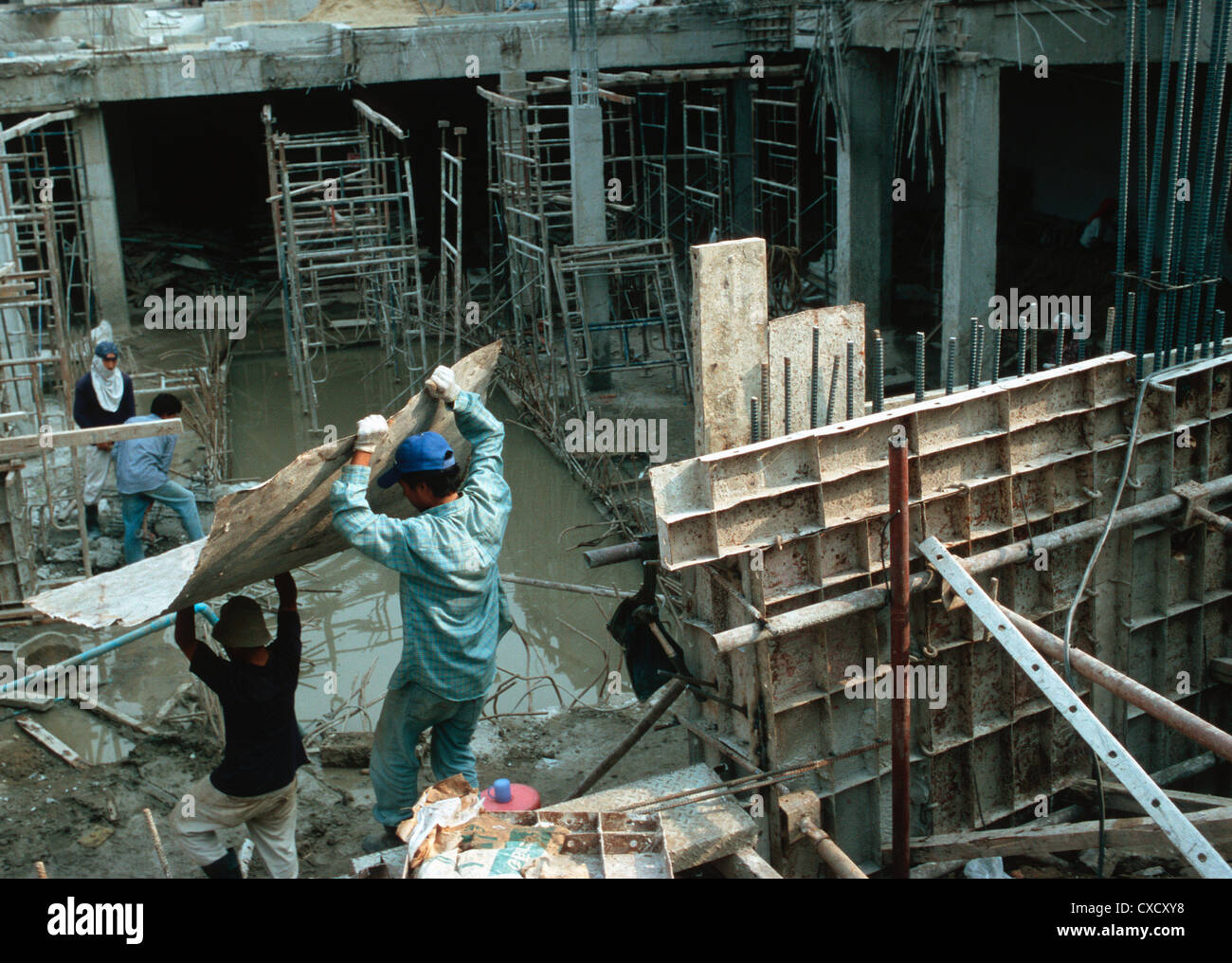 Bangkok, Männer tragen einen Teller auf einer Baustelle Stockfoto