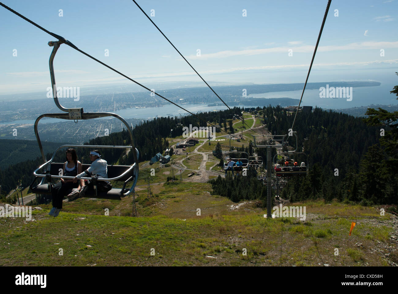 Ein Skilift auf Grouse Mountain mit Blick auf English Bay in Vancouver Stockfoto