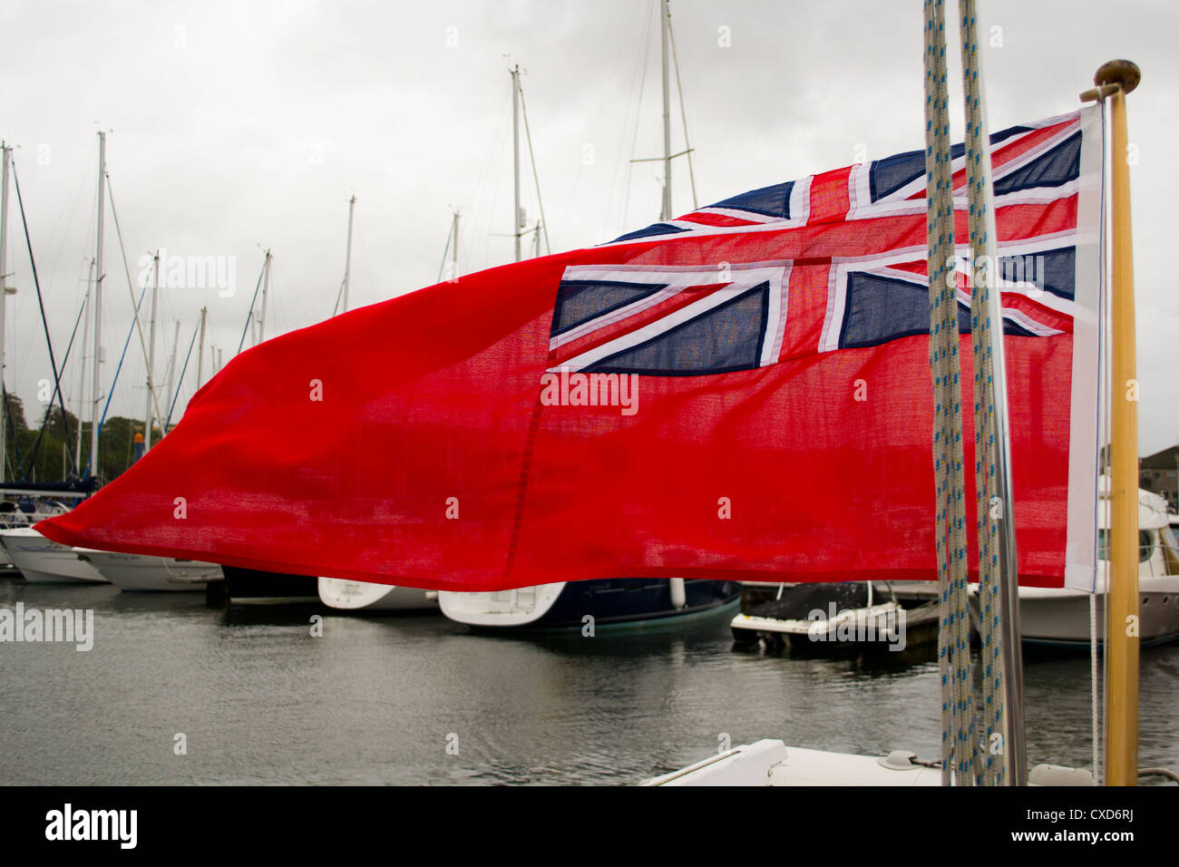 Red Ensign fliegen am Heck eines Bootes in einer Marina, Falmouth, UK. Stockfoto