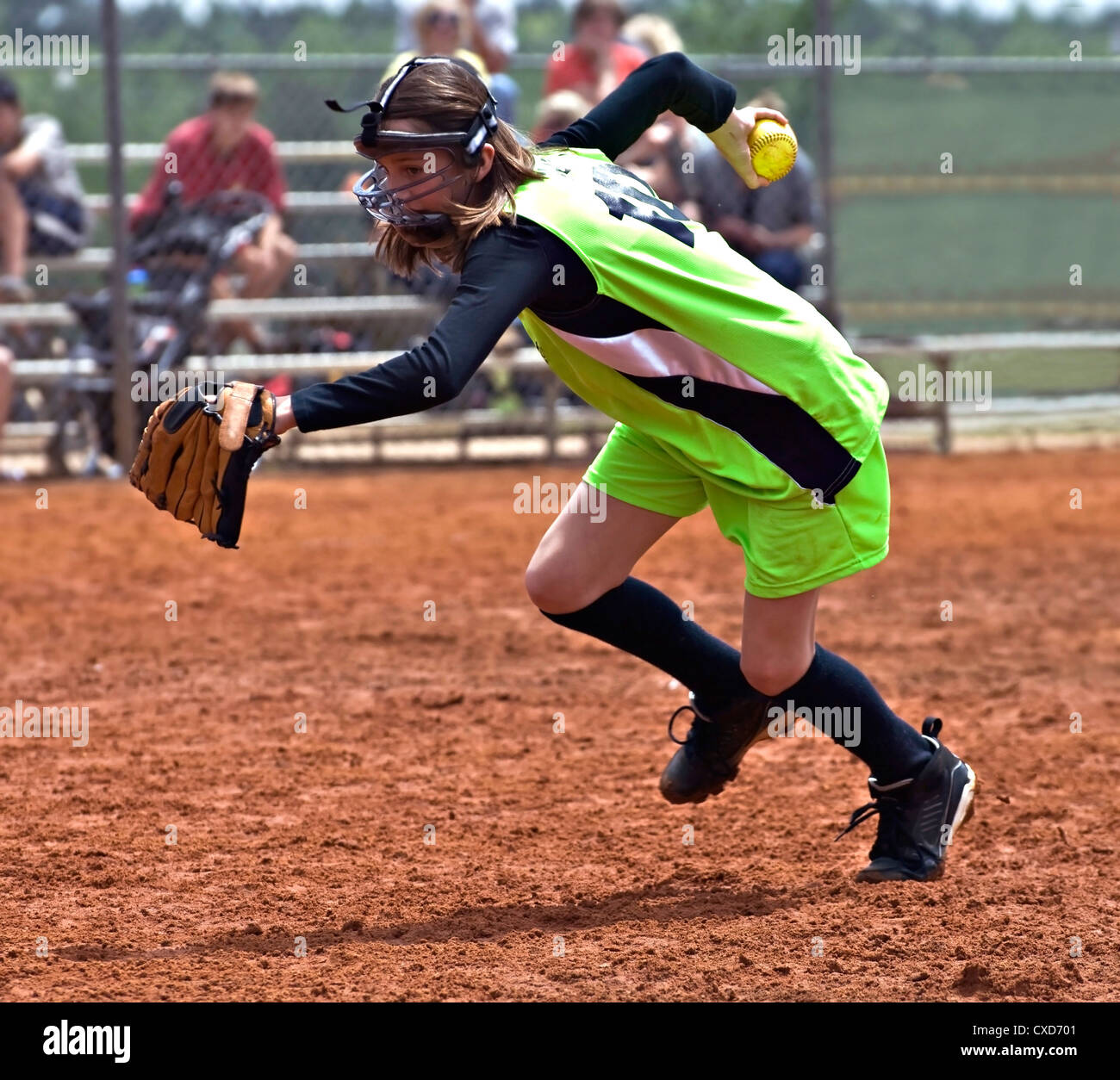 Ein junger Krug mit Ball in der hand Rennen, um eine in einem Softballspiel machen. Stockfoto