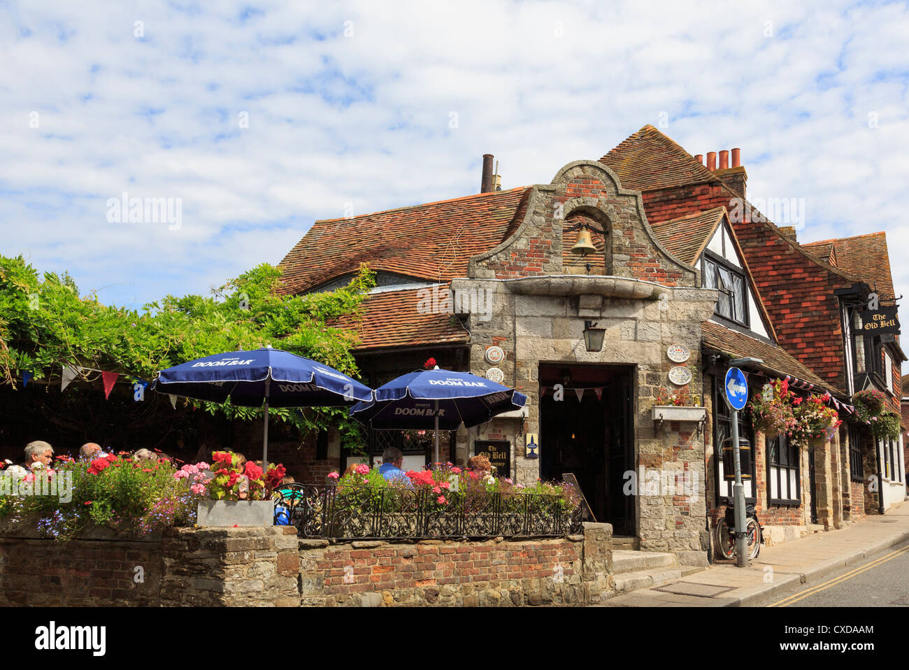 Ye Old Bell Inn Schmuggler-Pub aus dem 15. Jahrhundert in der historischen Hafenstadt Cinque mit Leuten, die im Sommer draußen sitzen. Roggen Sussex England Großbritannien Stockfoto
