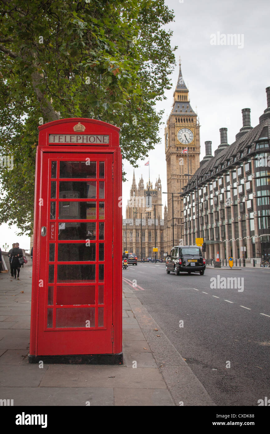 Eine rote Telefonzelle in London mit Big Ben und London Taxi im Hintergrund Stockfoto