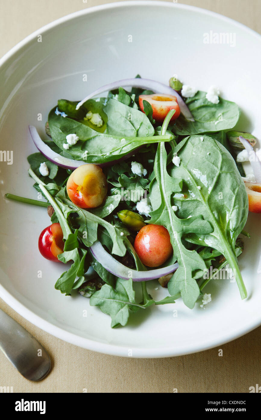 Grüner Salat mit Kirschen Stockfoto