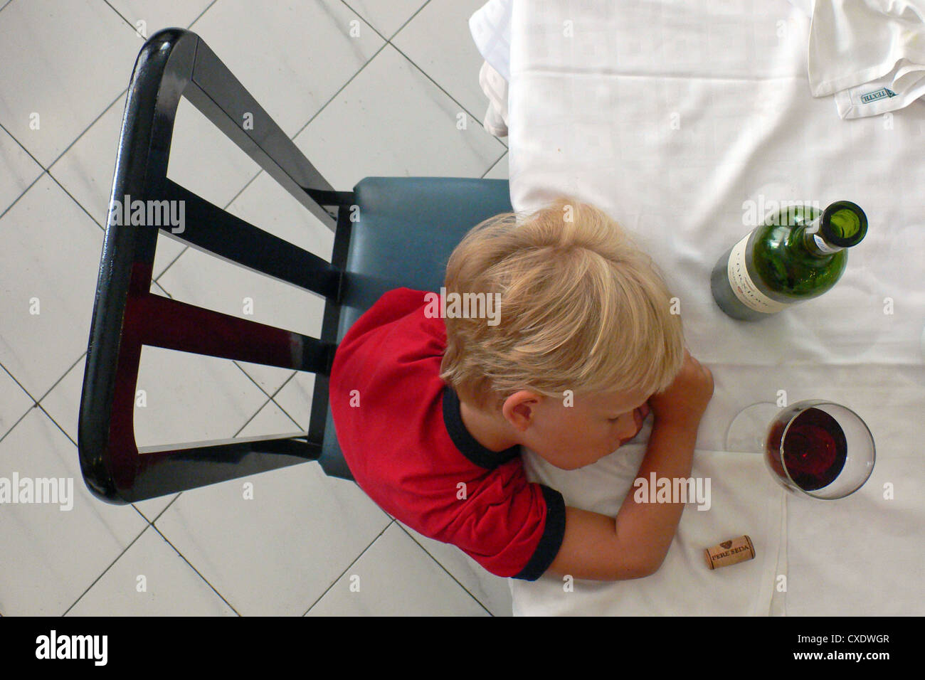 Cala Esmeralda, ein Kind am Tisch eingeschlafen ist Stockfoto