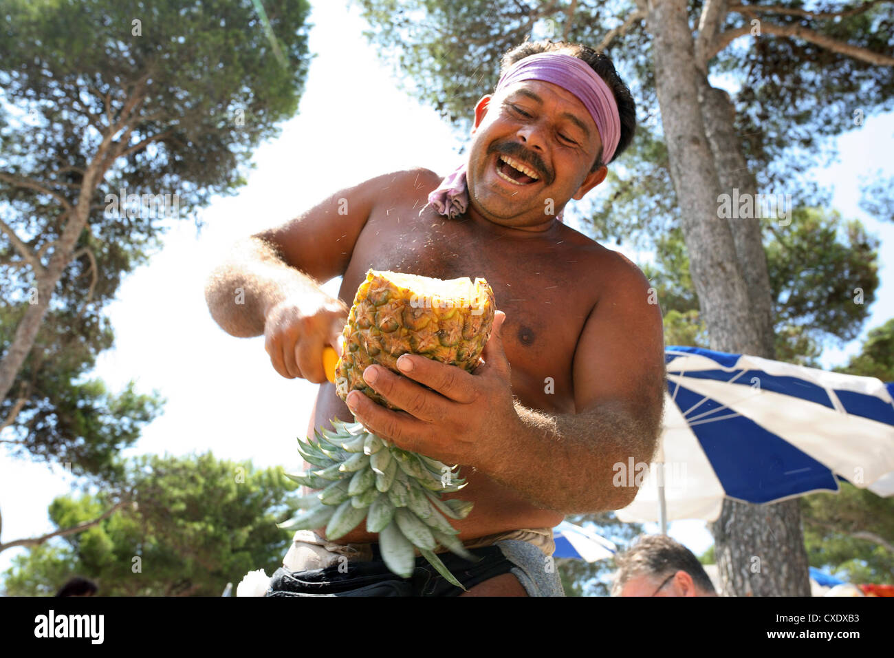 Cala D'Or, ein Mann eine Ananas schneiden Stockfoto