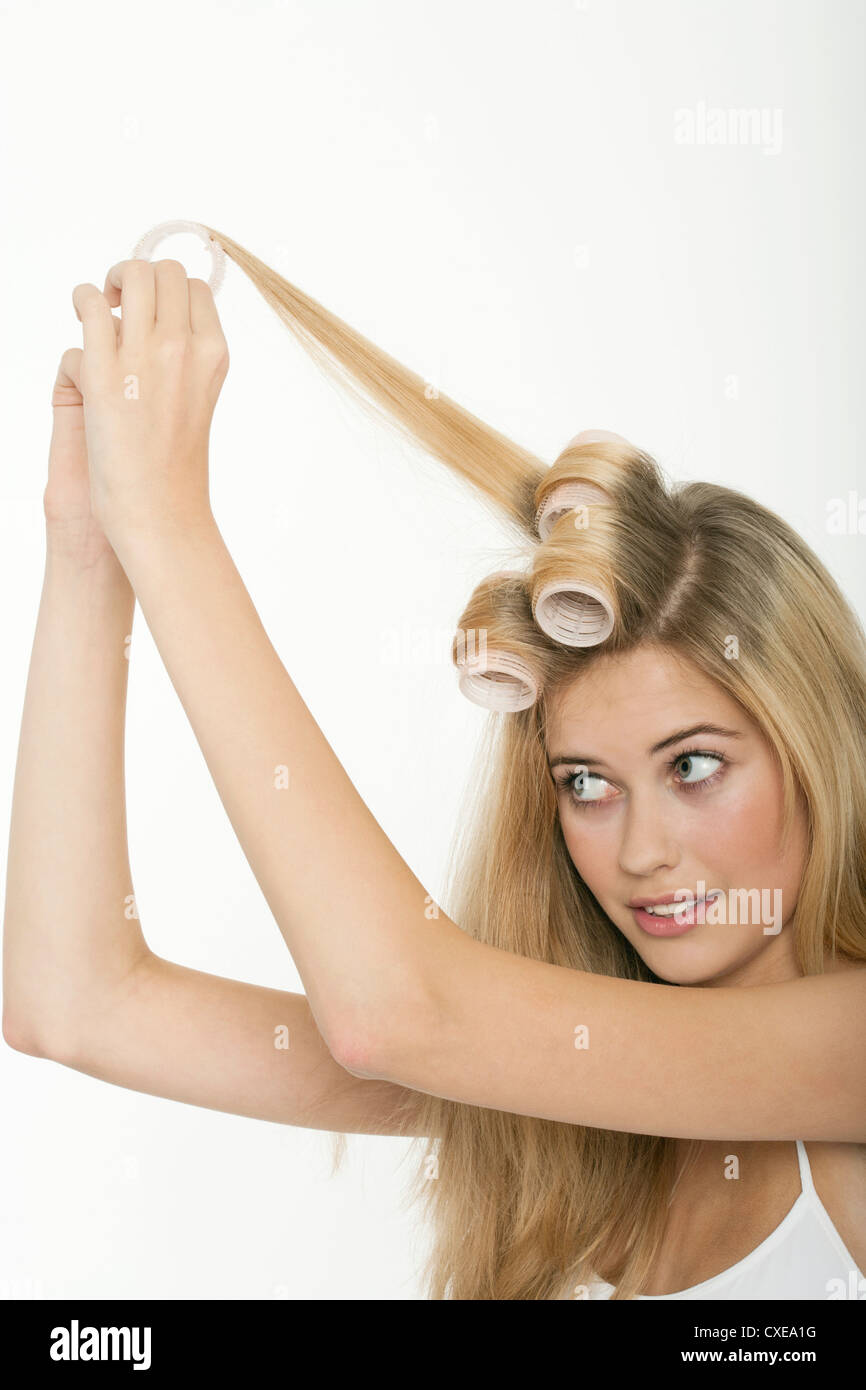 Teengirl Rollen ihre Haare mit Lockenwicklern Stockfoto