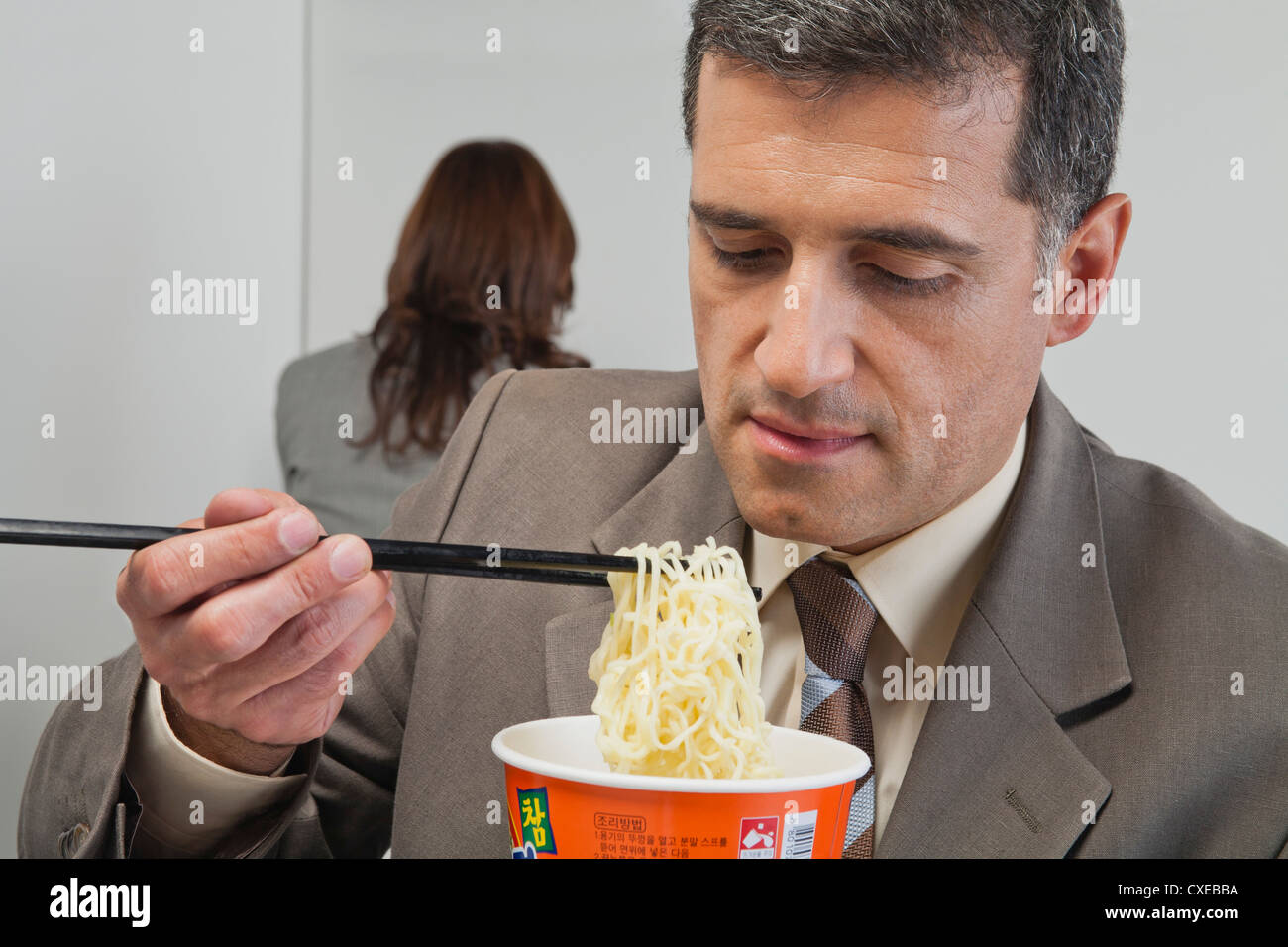 Kaufmann Essen Ramen-Nudeln im Büro Stockfoto