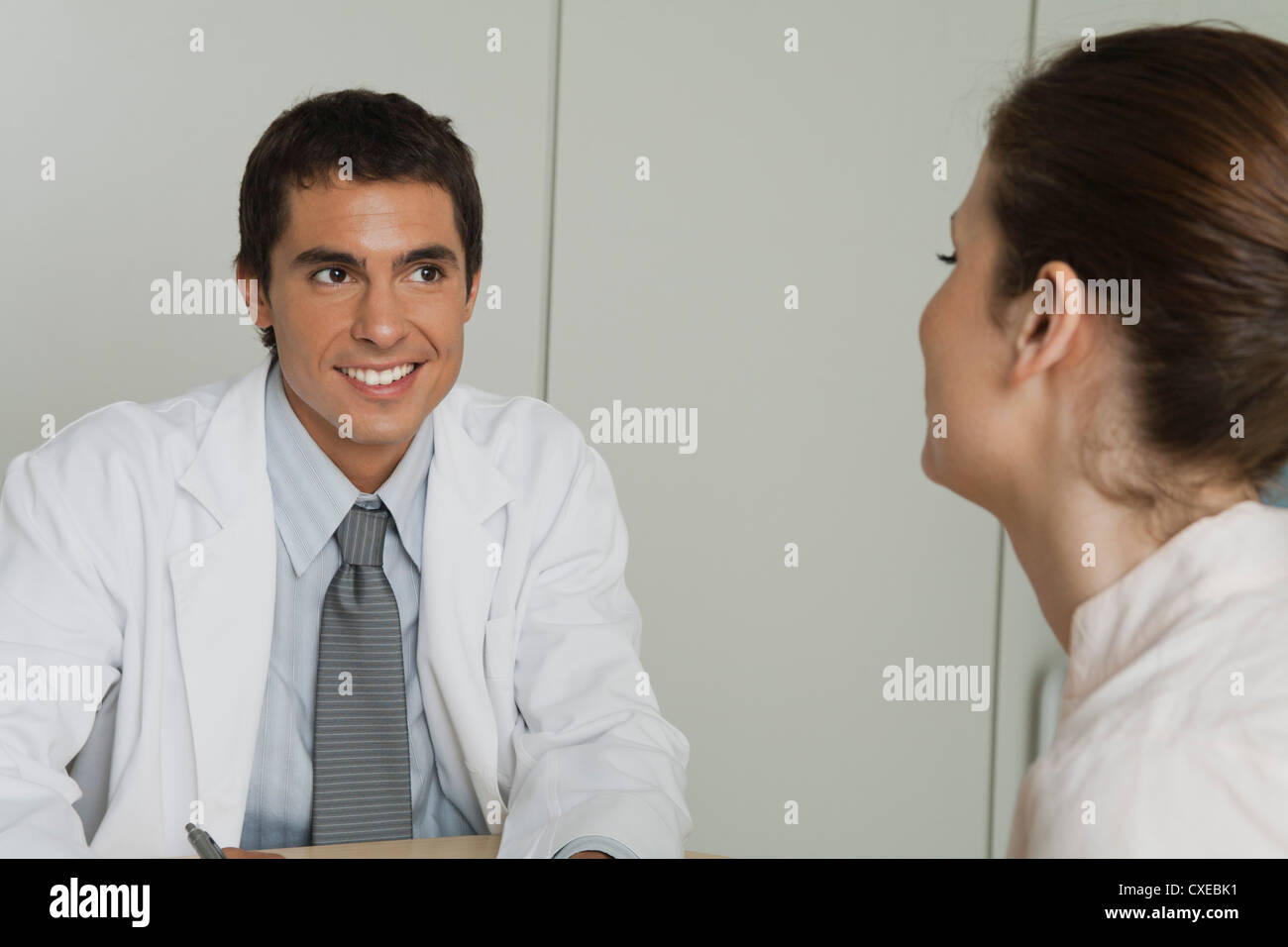 Arzt gegenüber Patientin sitzt Stockfoto