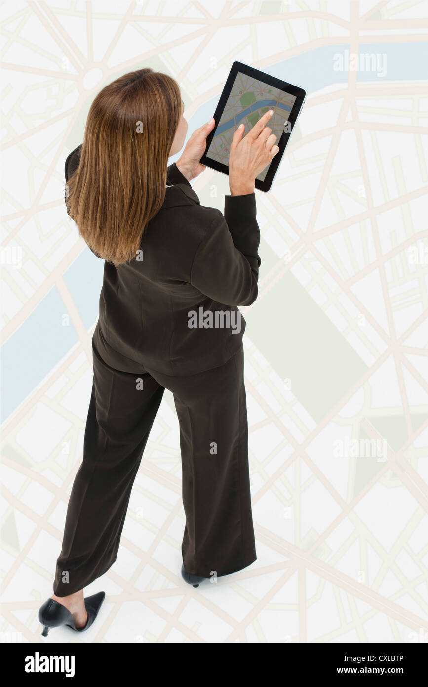 Frau auf der Suche auf Karte auf digital-Tablette während des Gehens auf große Karte Stockfoto