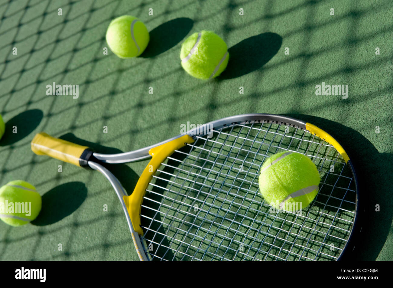 Eine Gruppe von Tennisbälle und Tennisschläger auf einem frisch gestrichenen Zement-Tennisplatz Stockfoto