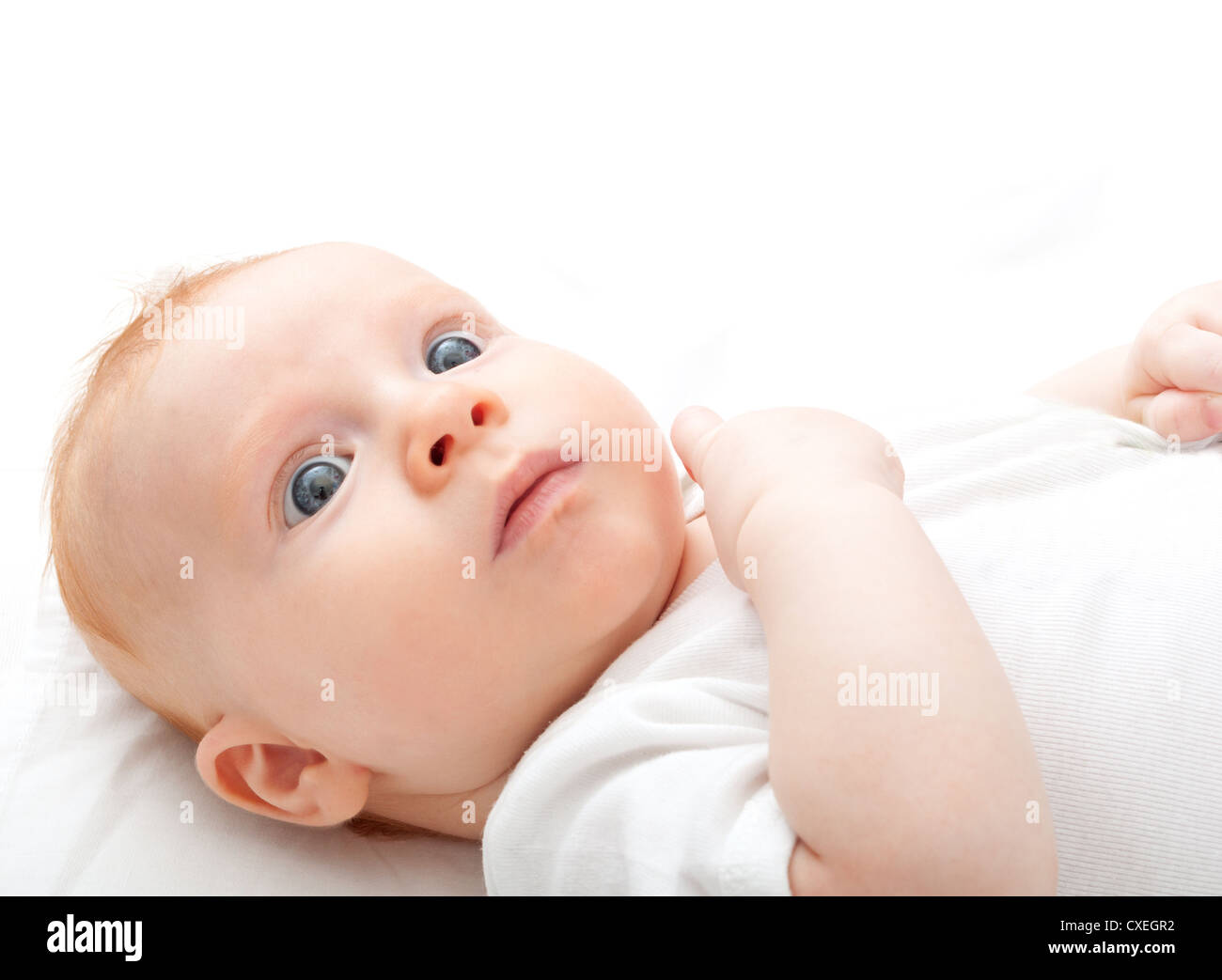 Baby liegend auf Rückseite auf weißem Hintergrund Stockfoto