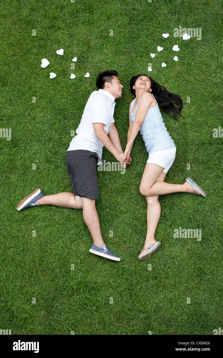Junge Liebhaber Flüstern auf Wiese Stockfoto