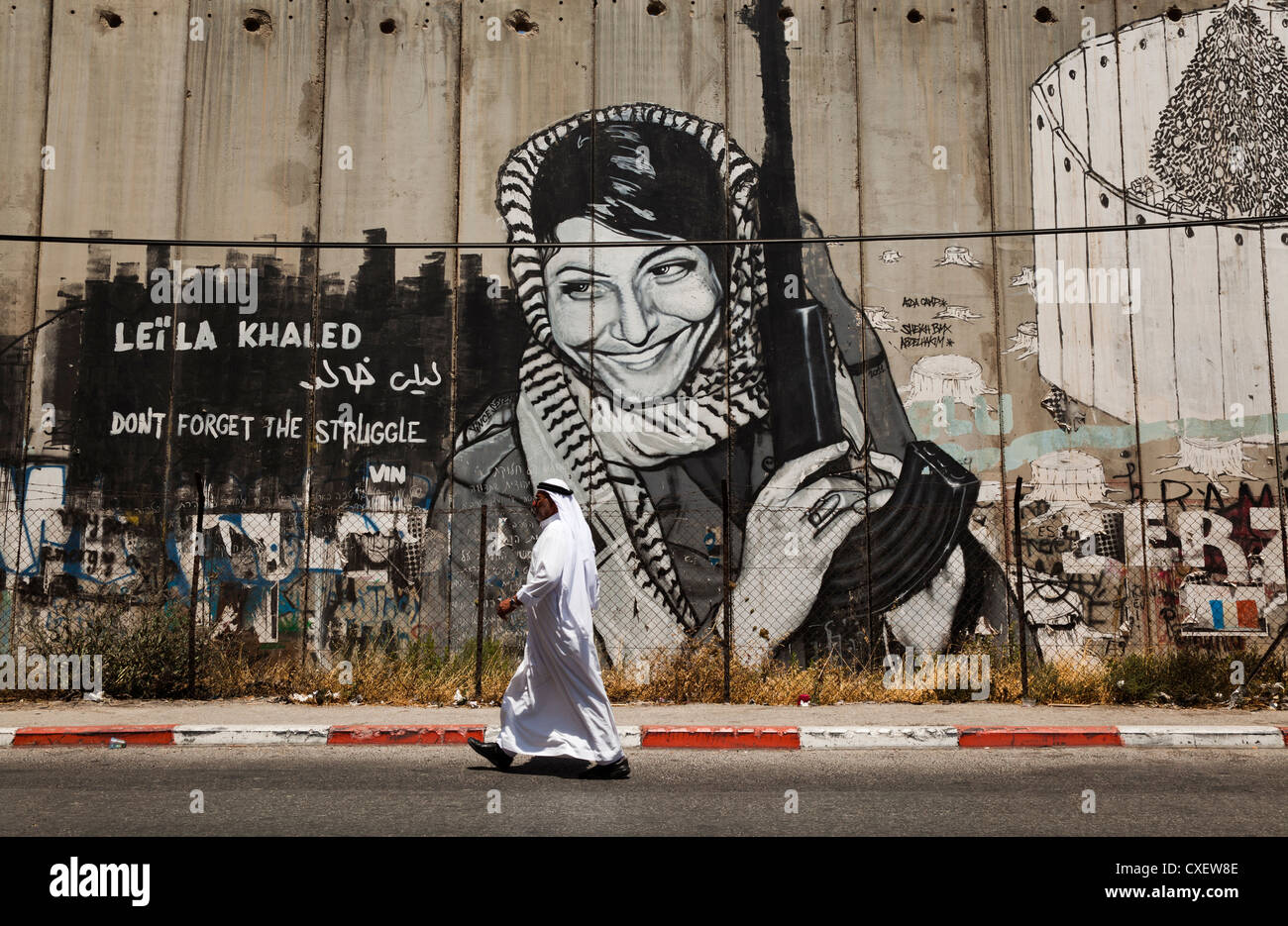 Arabischen Beduinen geht es vorbei an der israelischen Sicherheitsmauer oder "Westjordanland Barriere" Bethlehem Stadt. Das Wandbild ist Leila Khaled, Stockfoto