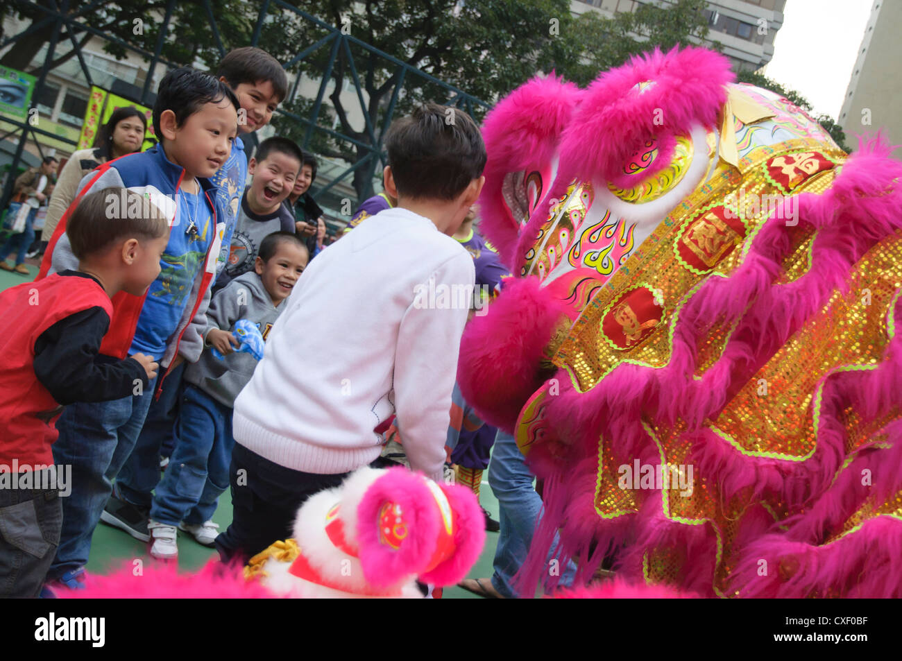 Kinder spielen an einem traditionellen Löwentanz in Wan Chai, Hong Kong Stockfoto