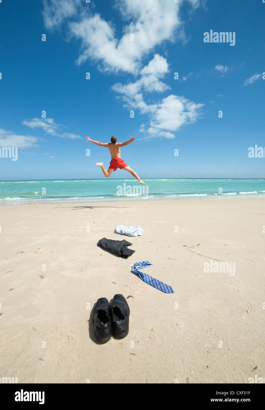 Geschäftsmann am Strand springen Stockfoto