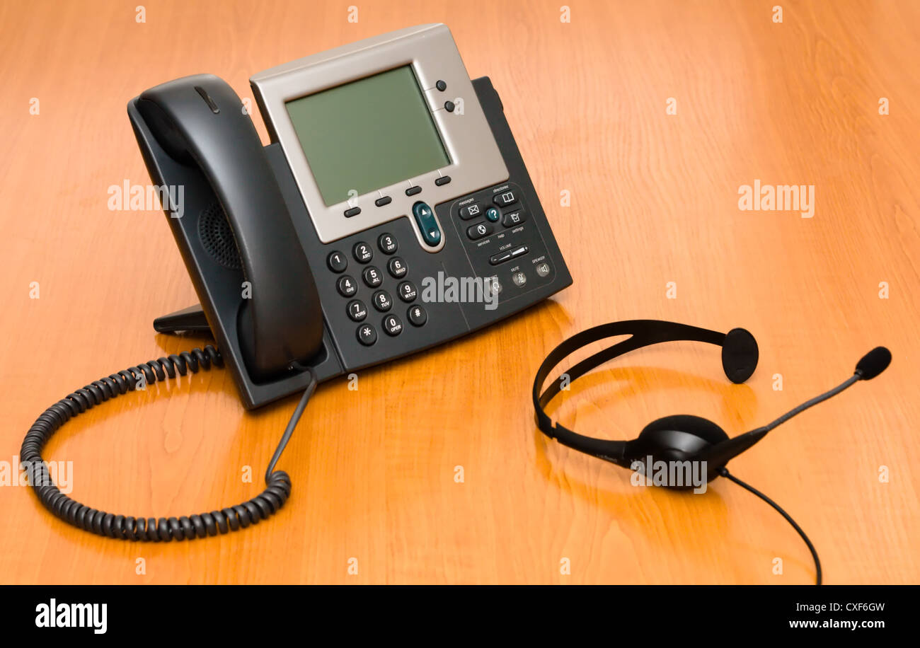 VoIP-Telefon mit einem Kopfhörer Stockfoto
