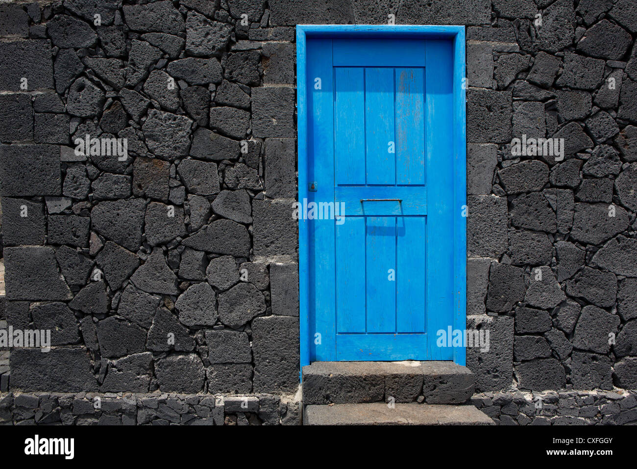 Blaue Tür im schwarzen Lava Stein Mauerwerk auf La Palma Kanarische Inseln Stockfoto