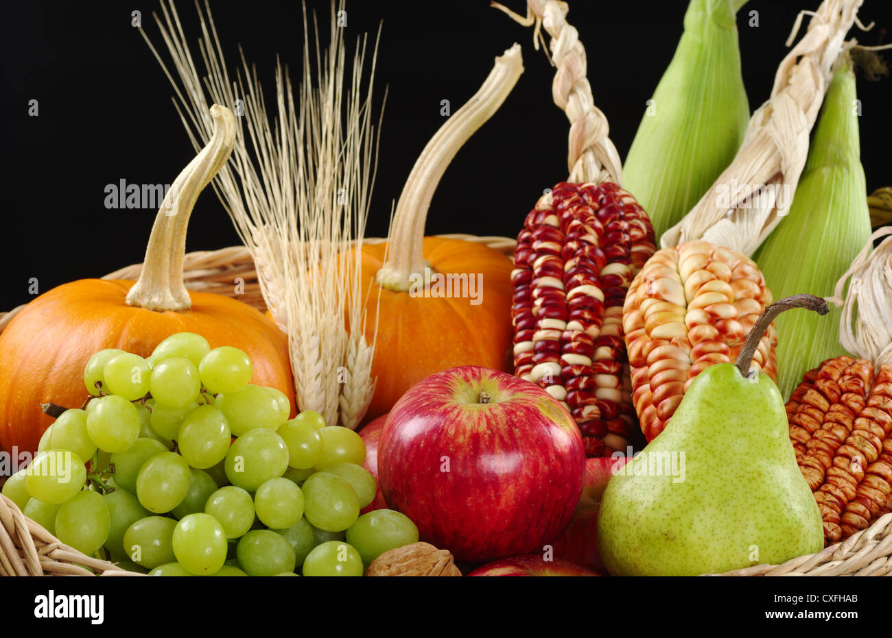 Ein Herbst Korb mit Äpfeln, Birnen, Trauben, Weizen, Mais und Kürbisse (selektiven Fokus, Fokus auf Apfel, Birnen und Trauben vor) Stockfoto