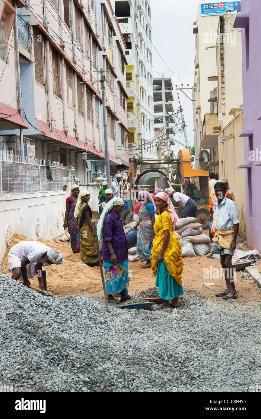 Indische Männer und Frauen, die Arbeiten auf den Straßen in Puttaparthi, Andhra Pradesh, Indien. Stockfoto