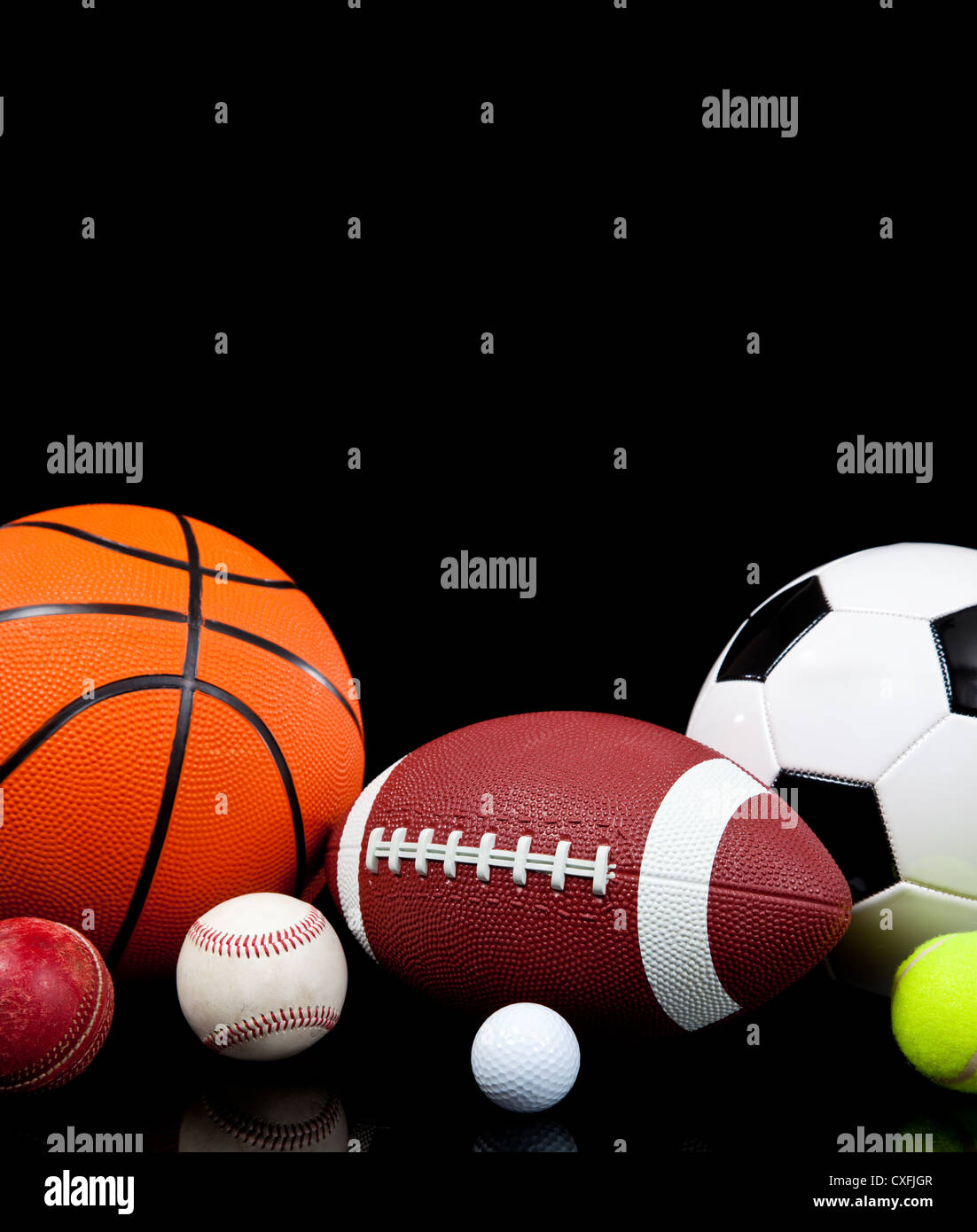 Sortierte Sportbälle auf einem schwarzen Hintergrund mit Textfreiraum Stockfoto