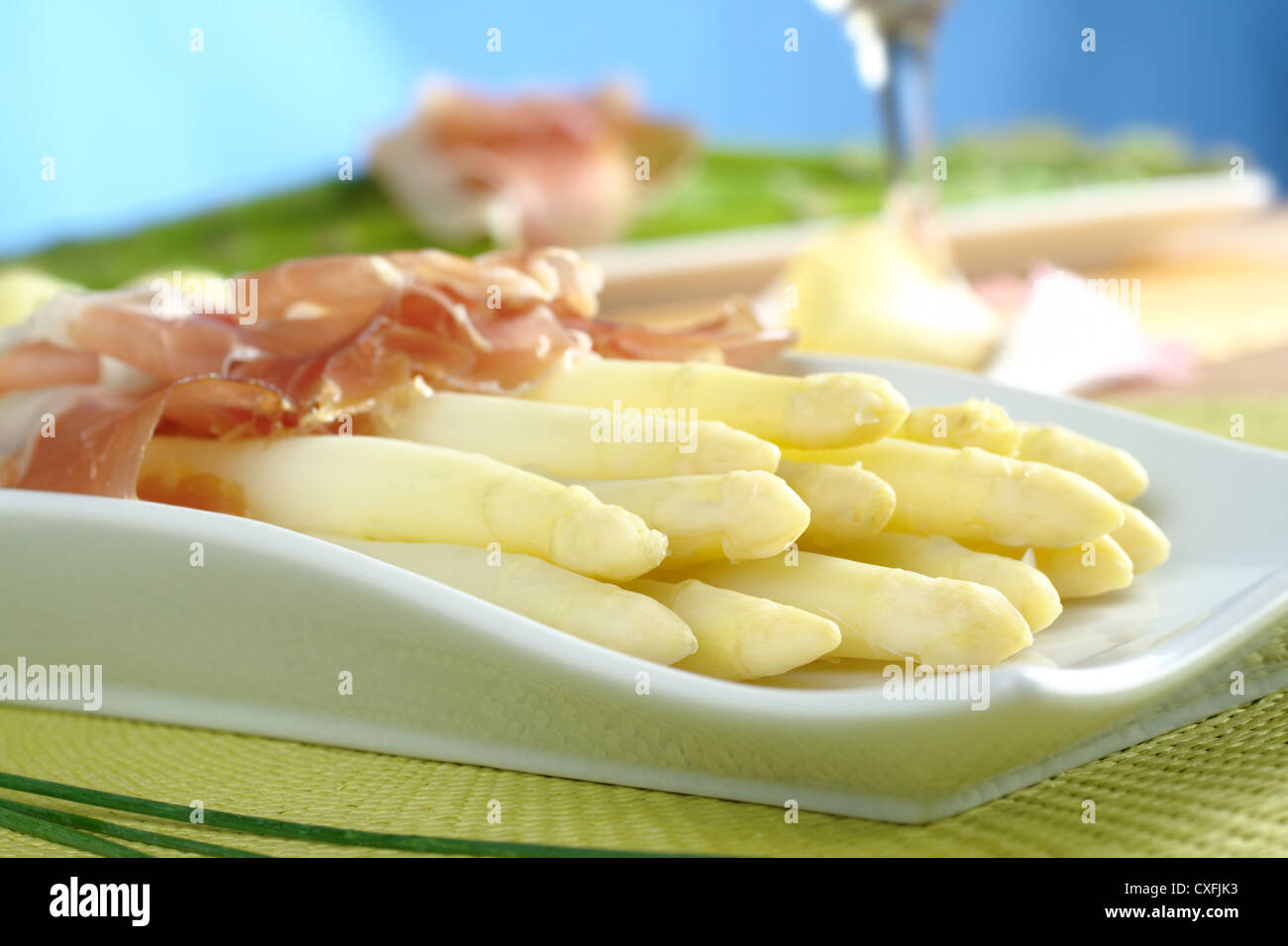 Frisch gekocht weißer Spargel mit Schinken mit Rotwein und grünem Spargel im Hintergrund serviert Stockfoto